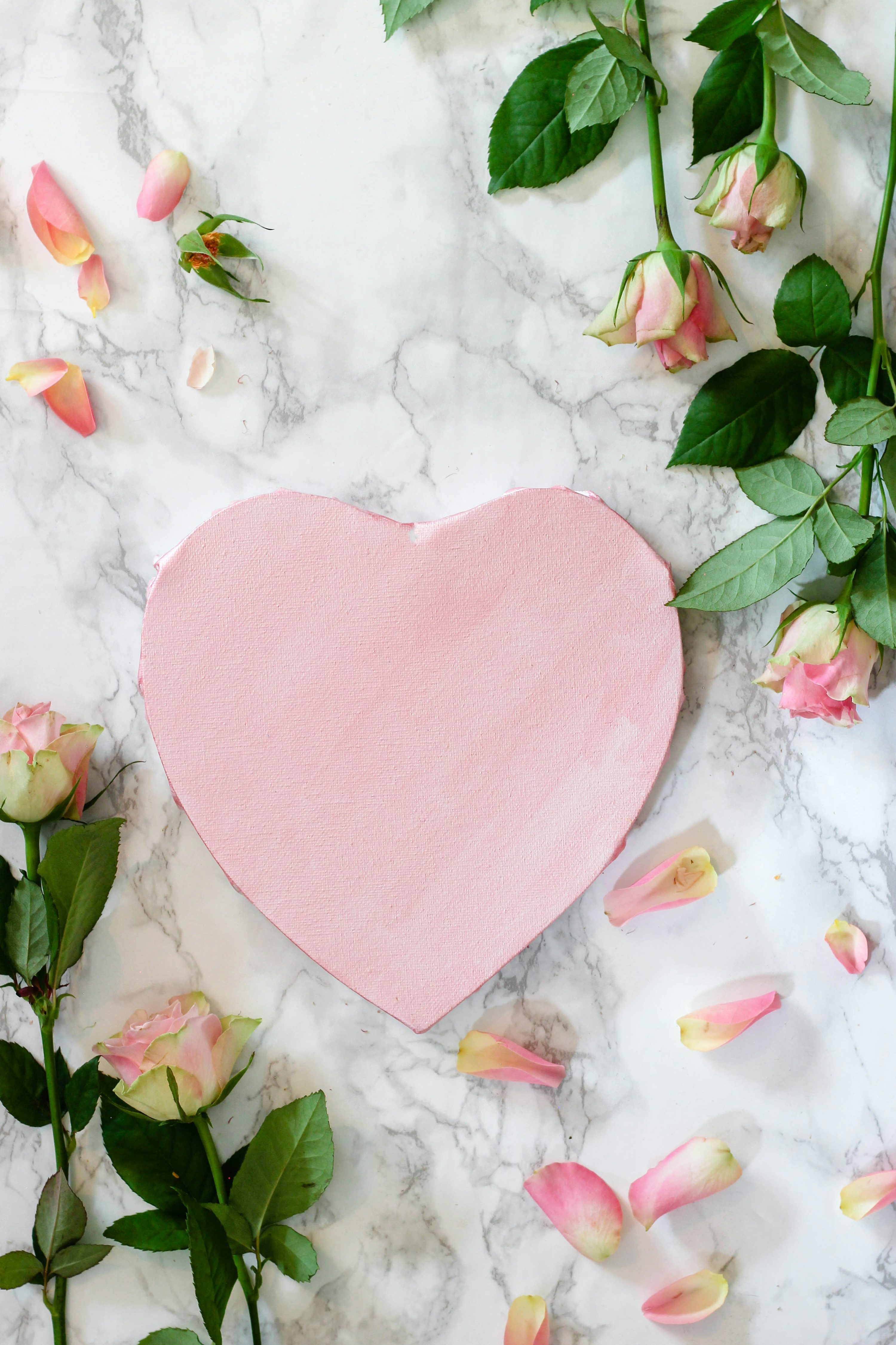 Pink heart shaped paper on white