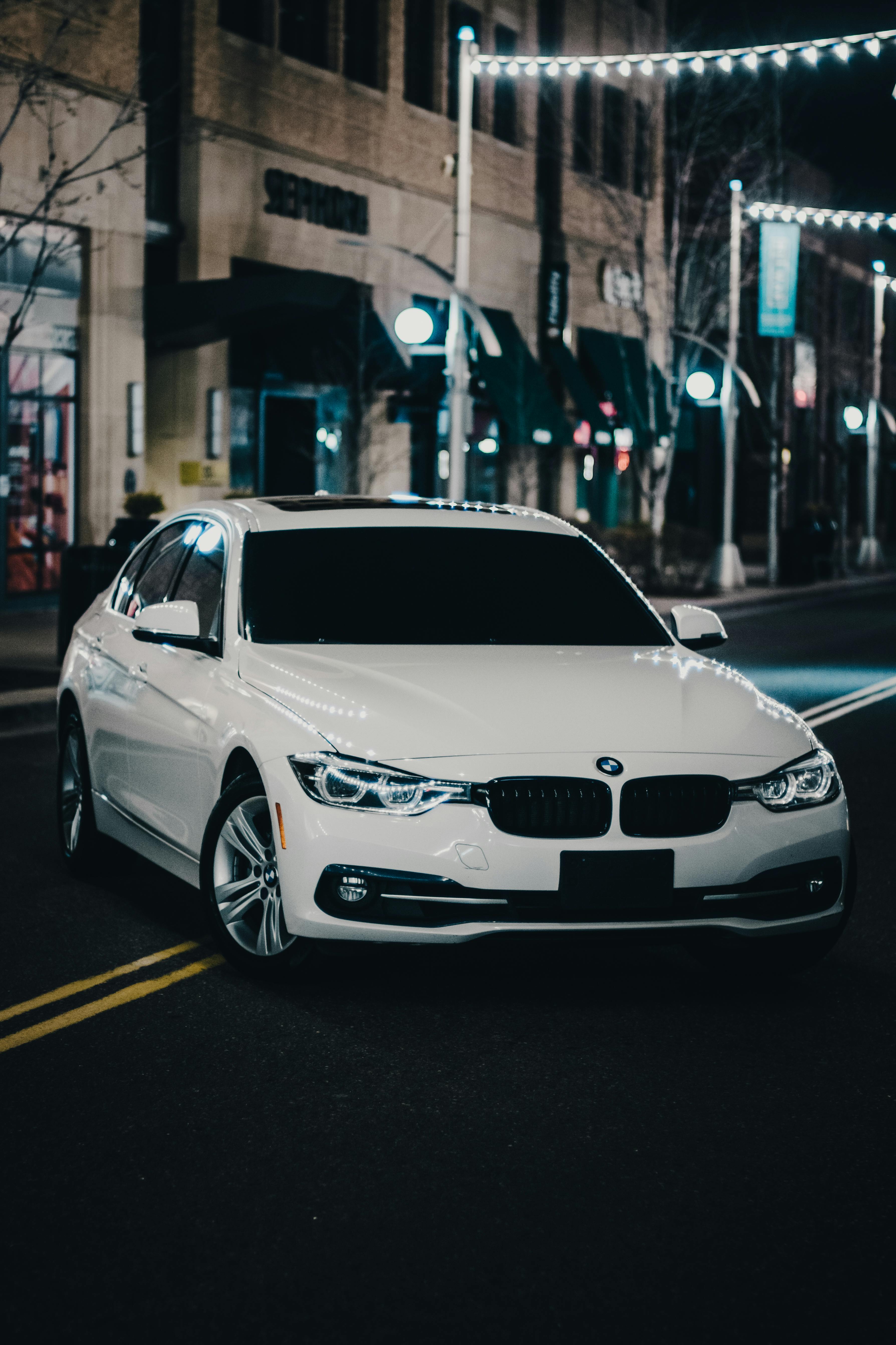 A White BMW on the Street at Night
