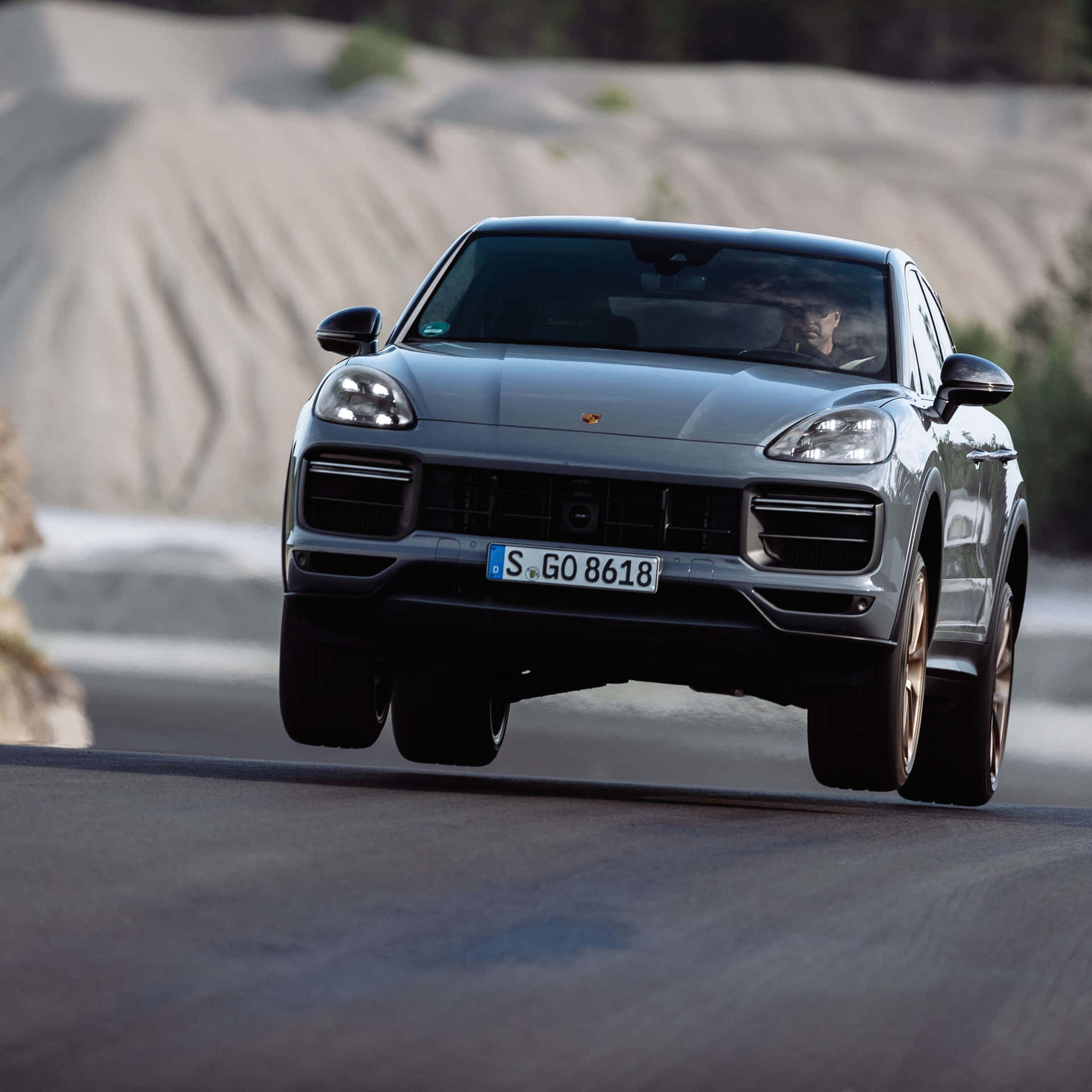 Download Caption: Sleek 2023 Porsche Cayenne Turbo Cruising On An Open Road. Wallpaper