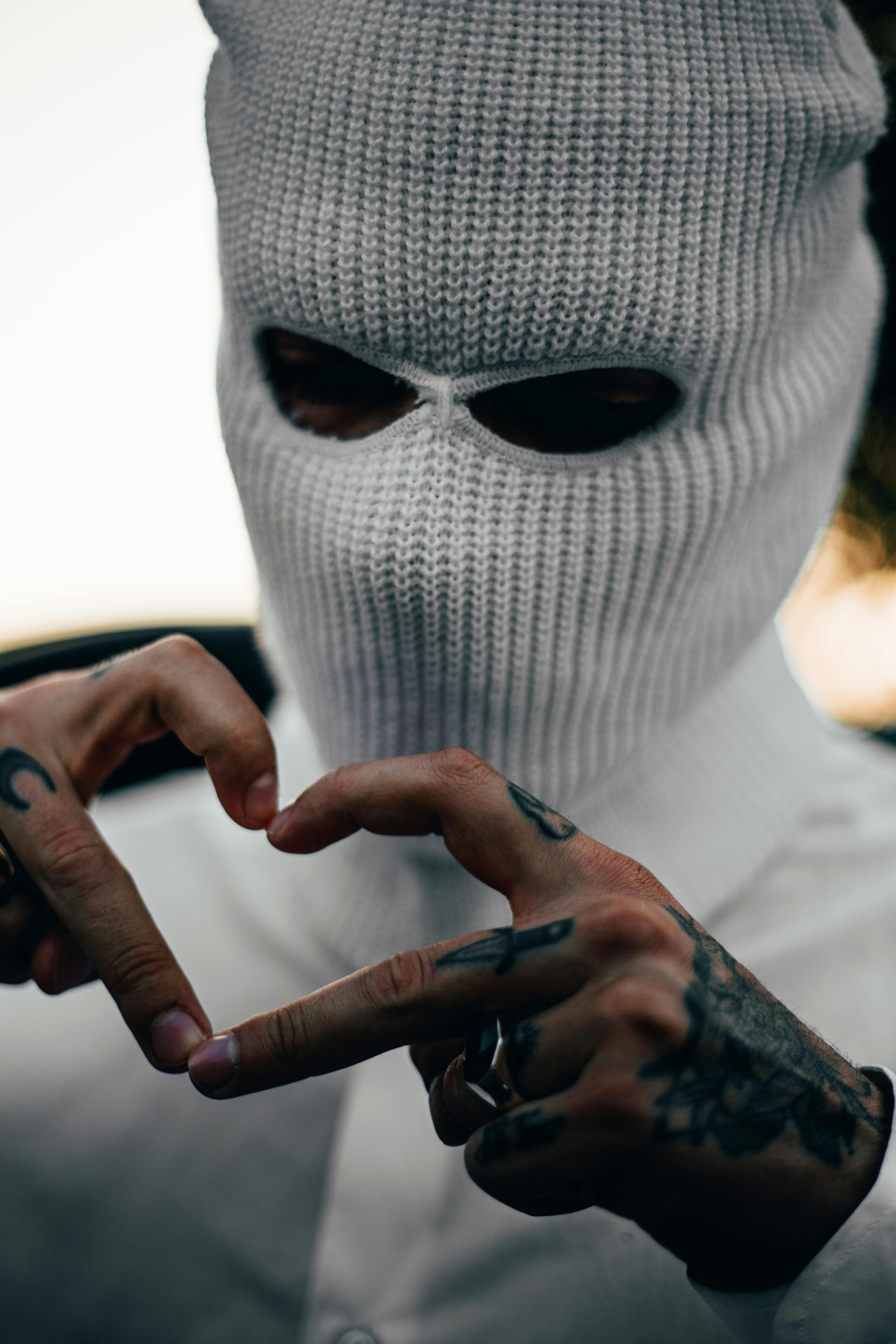 A Tattooed Man in a Ski Mask Making a