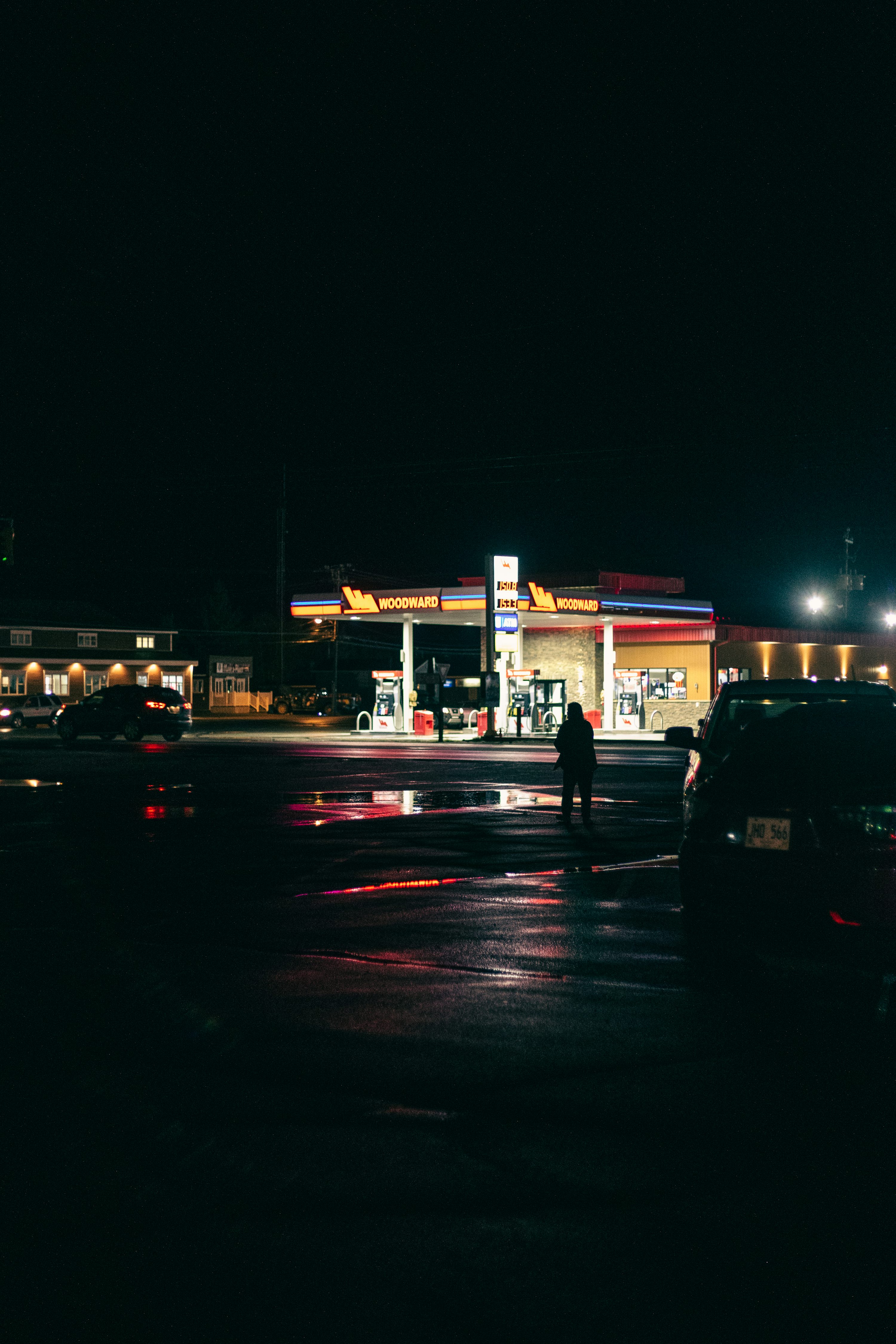 A gas station at night with cars parked