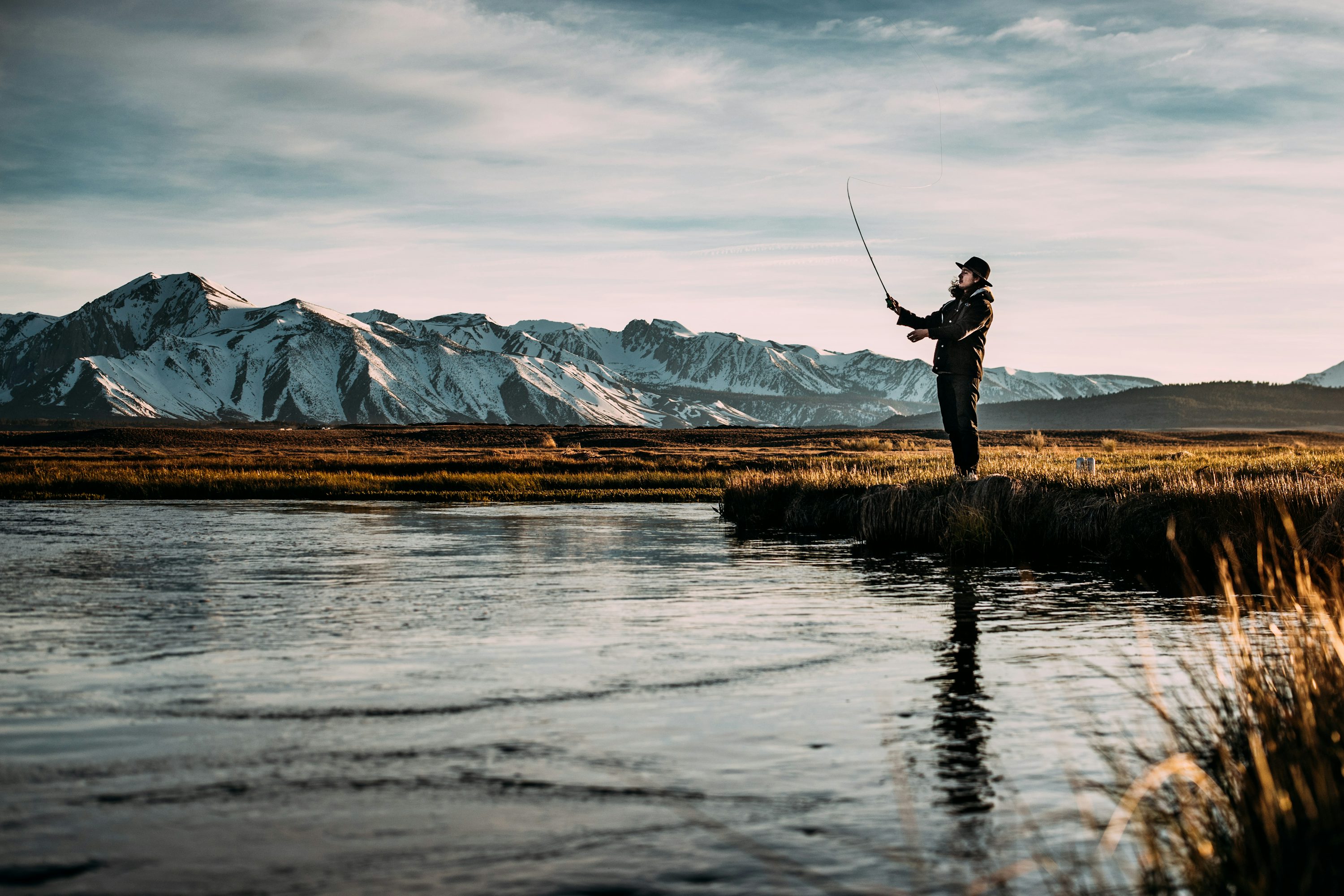 Landscape photo of man fishing on river