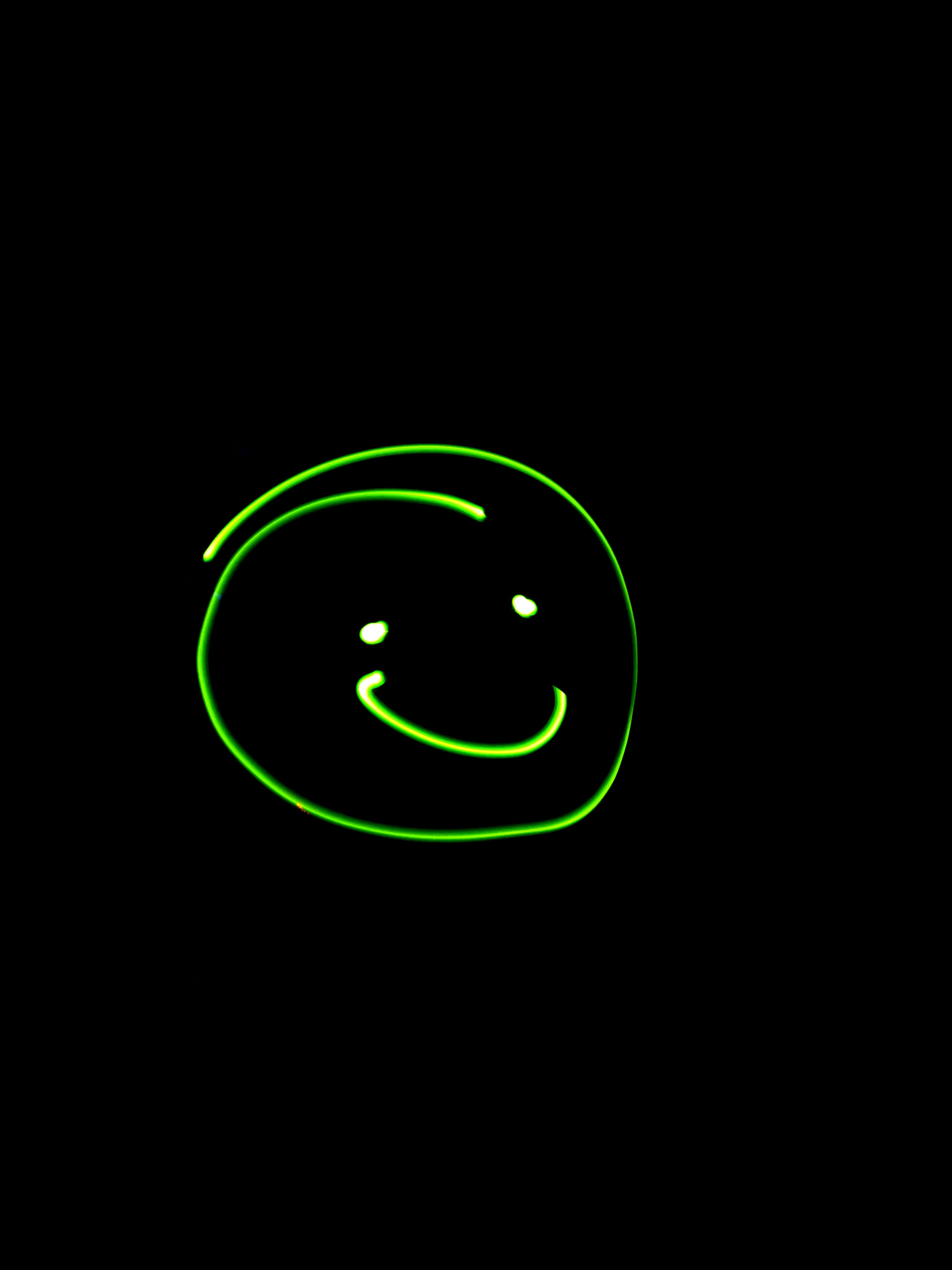 green smiley face on a black background