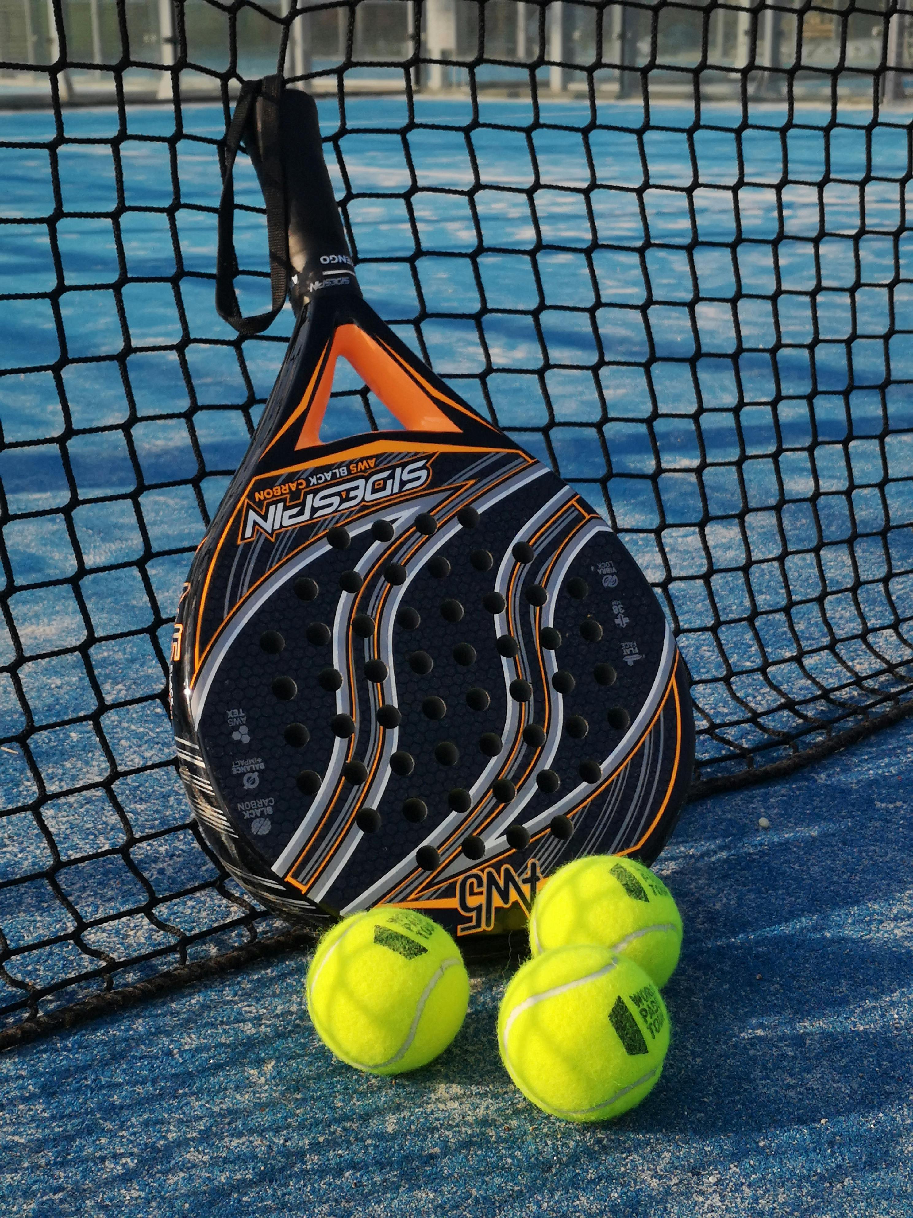 Padel racket and bright balls on tennis