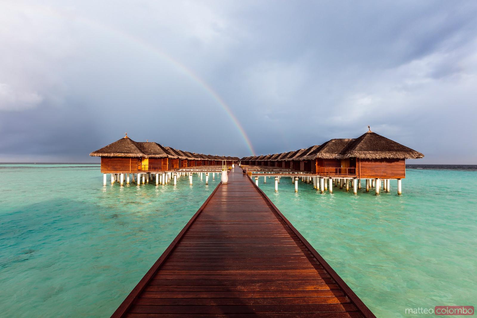 Rainbow over bungalows on an island