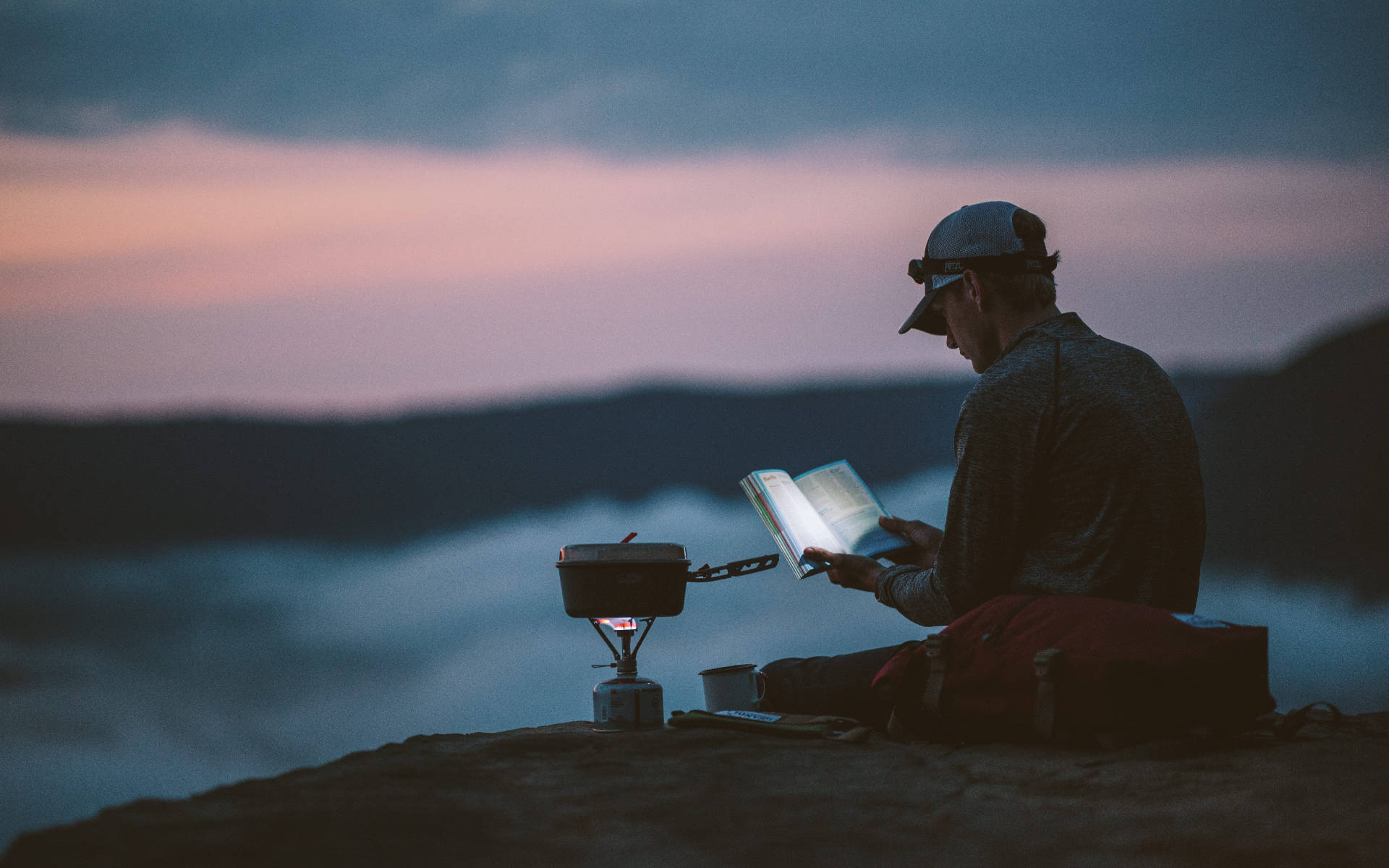 Download Hiker Reading Book In Mountain Wallpaper