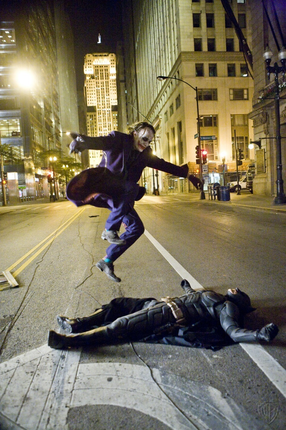 Heath Ledger kickflipping over Batman