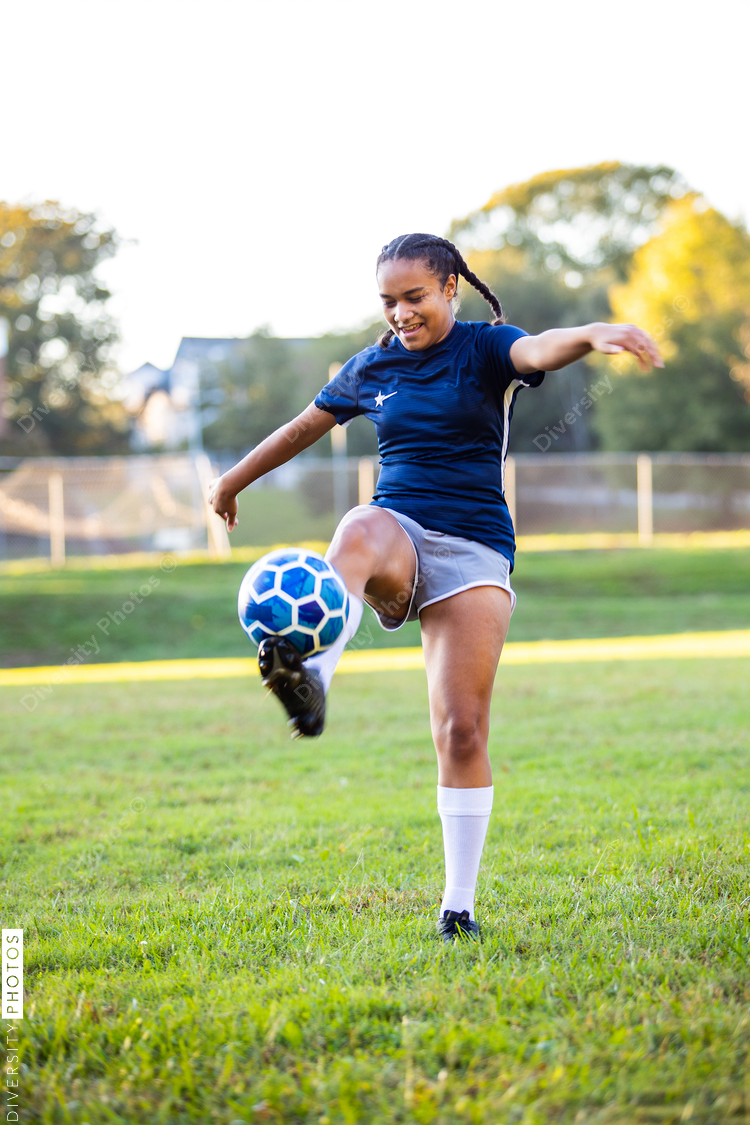 Mixed race female soccer player kicking