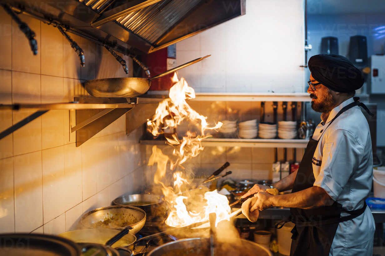 Indian chef flambing food in restaurant