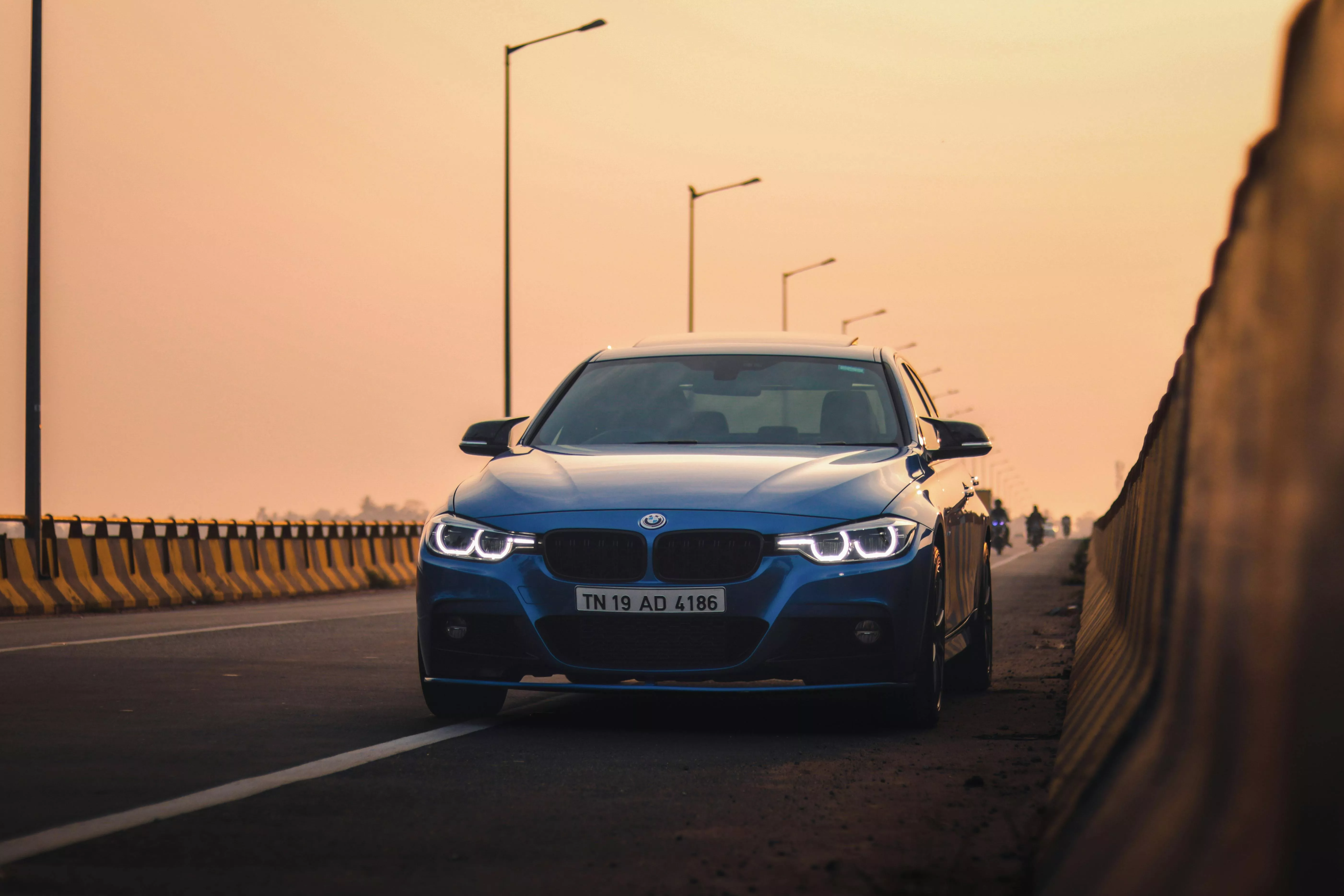 A Blue BMW F30 on a Street at Sunset