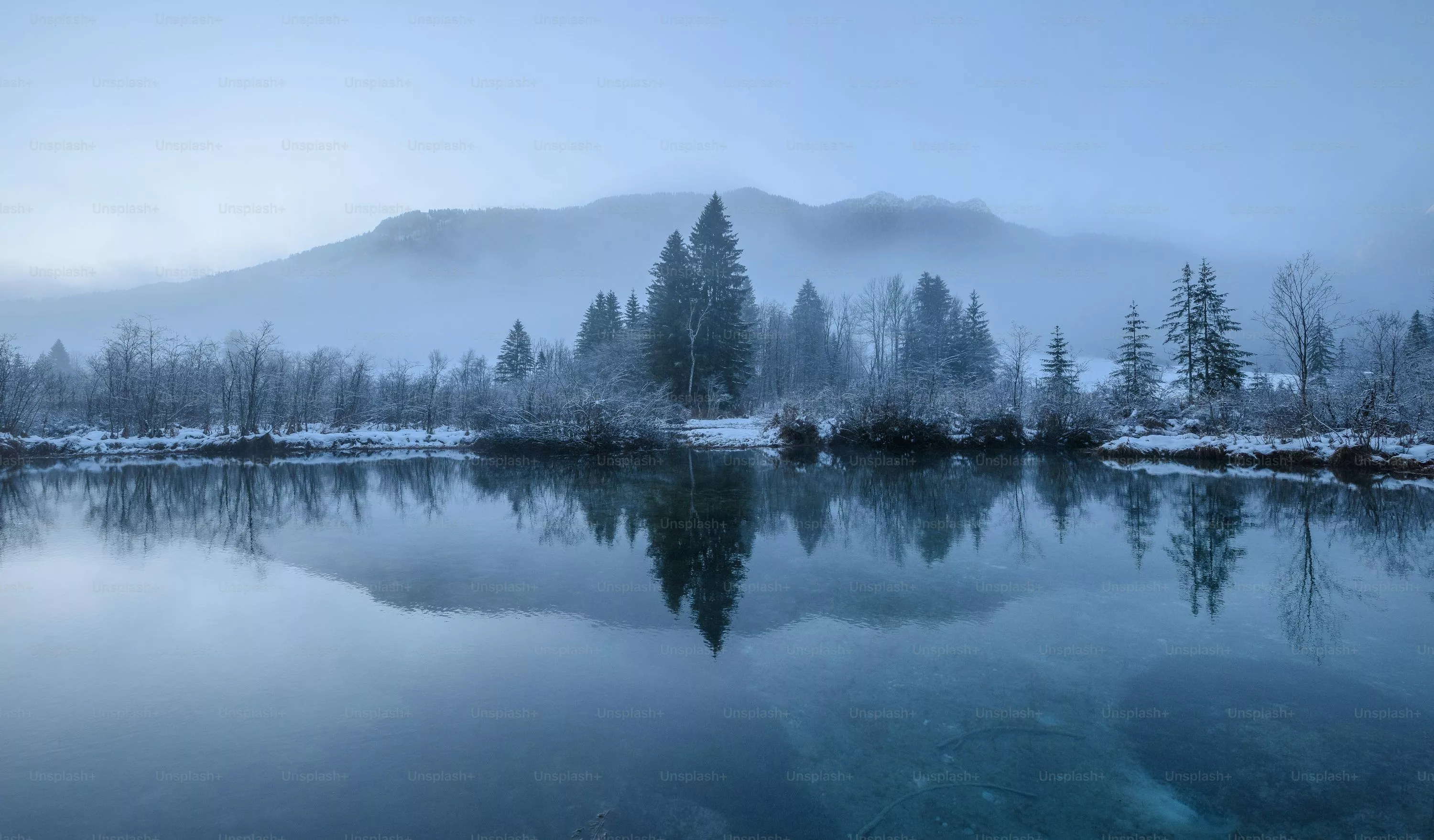 A lake with trees and mountains in