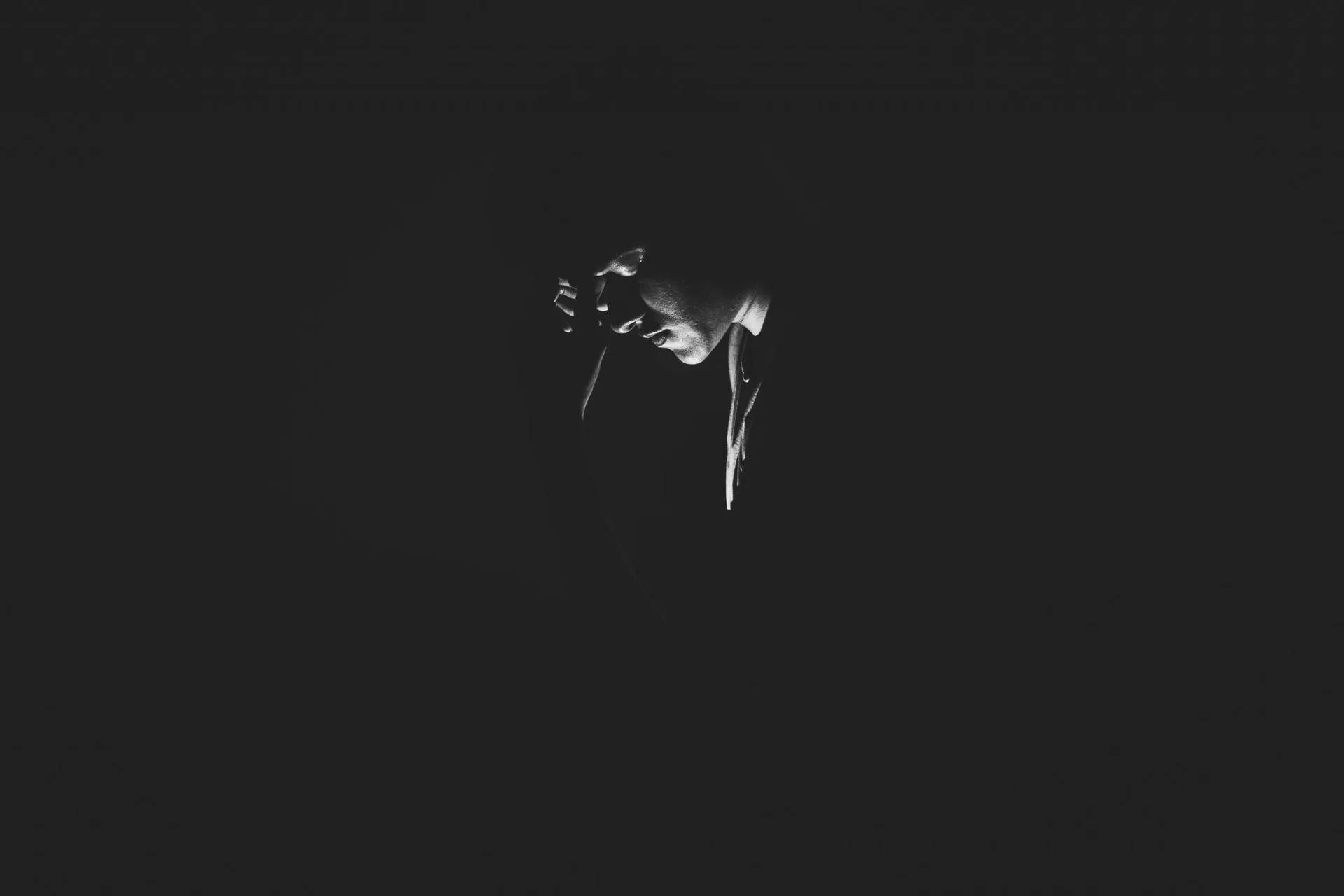 Download A Black And White Photo Of A Person In The Dark Wallpaper