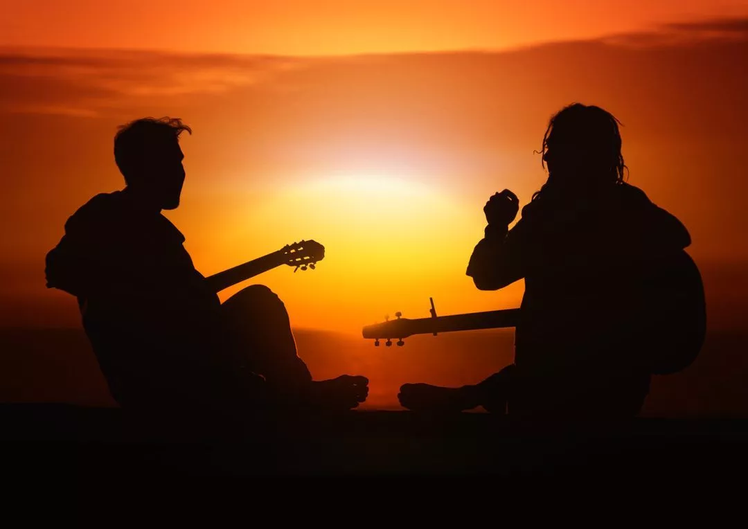 Silhouette of two guitarists playing at