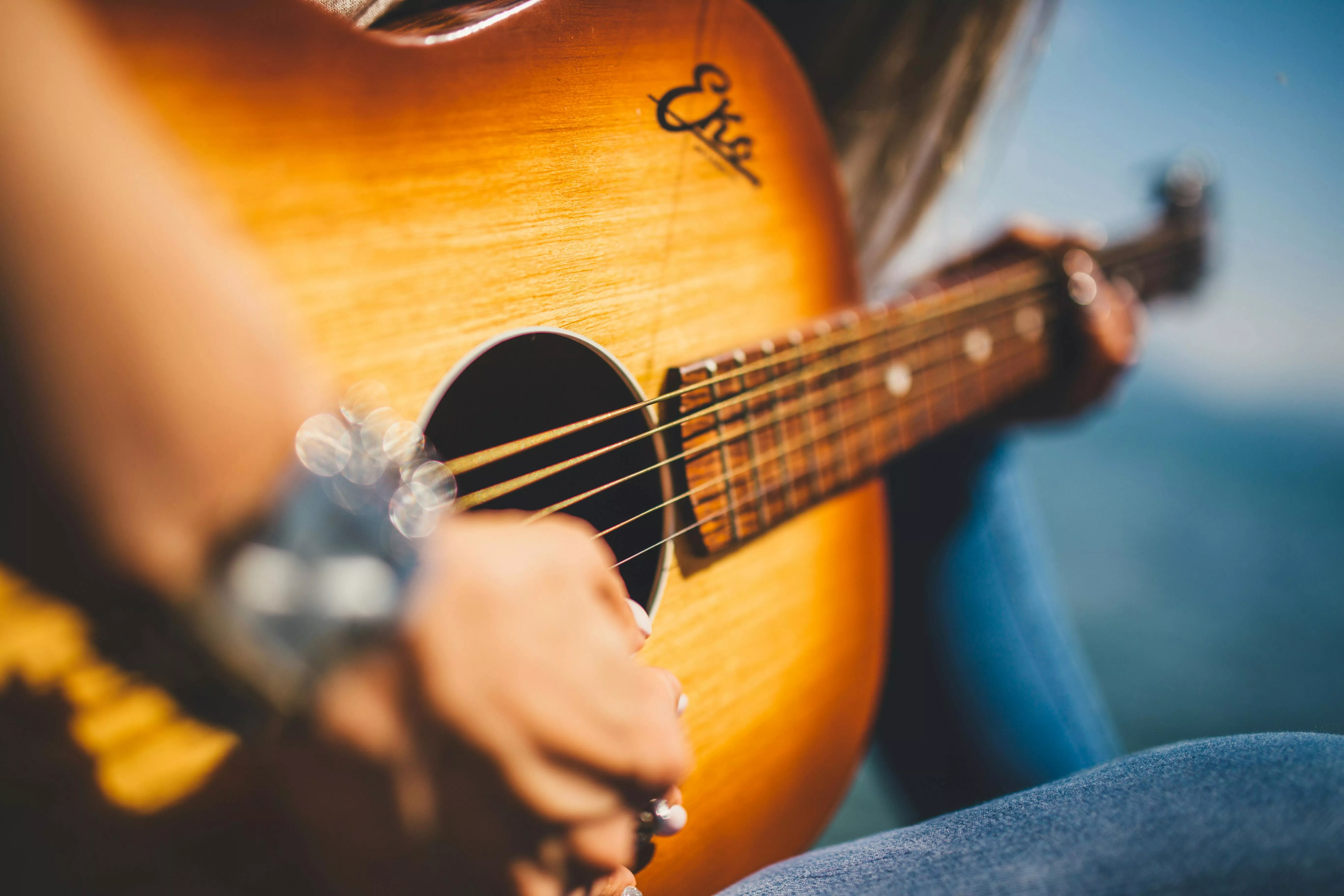 Person Play Guitar In Close Up Photo