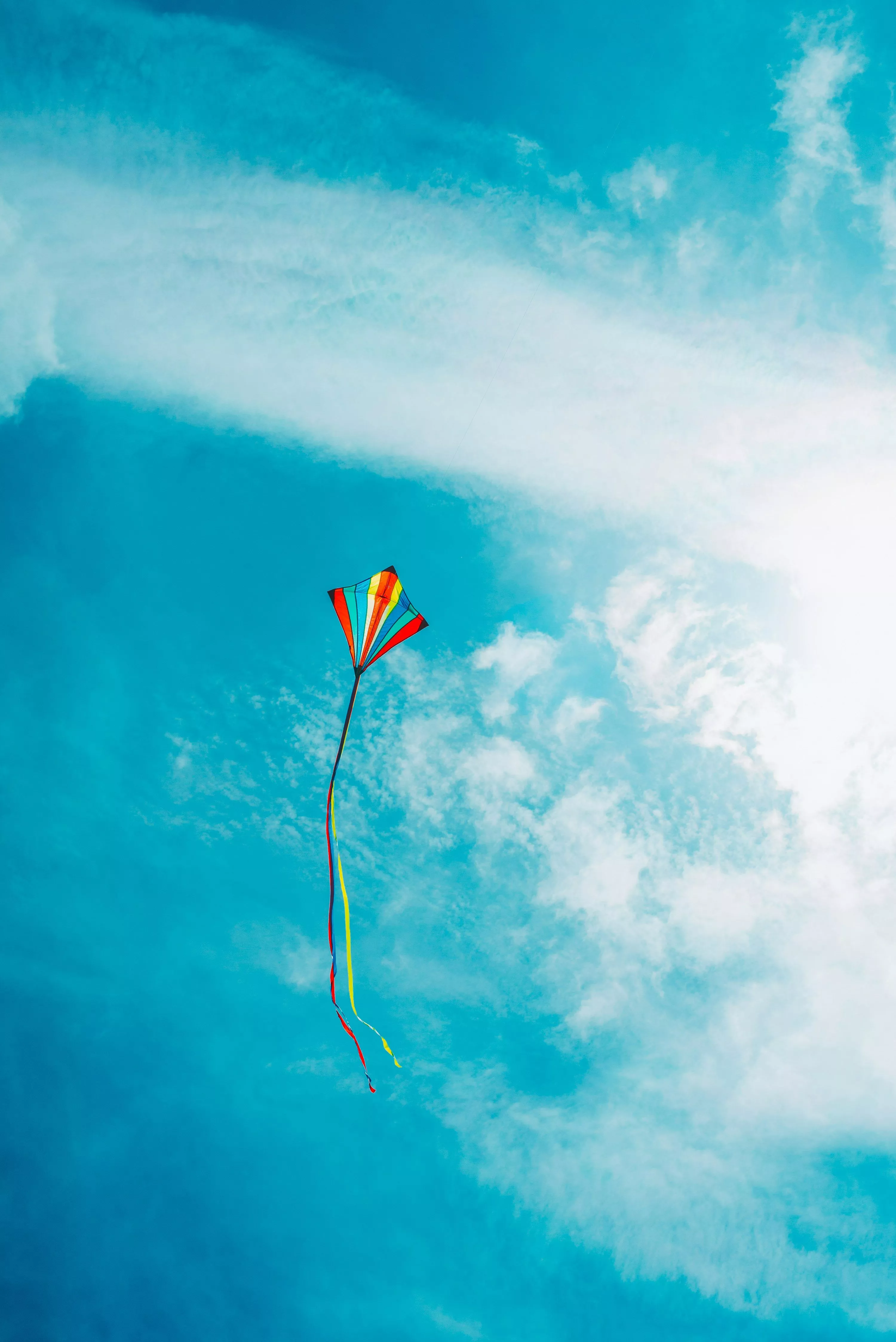 yellow kite flying under blue sky