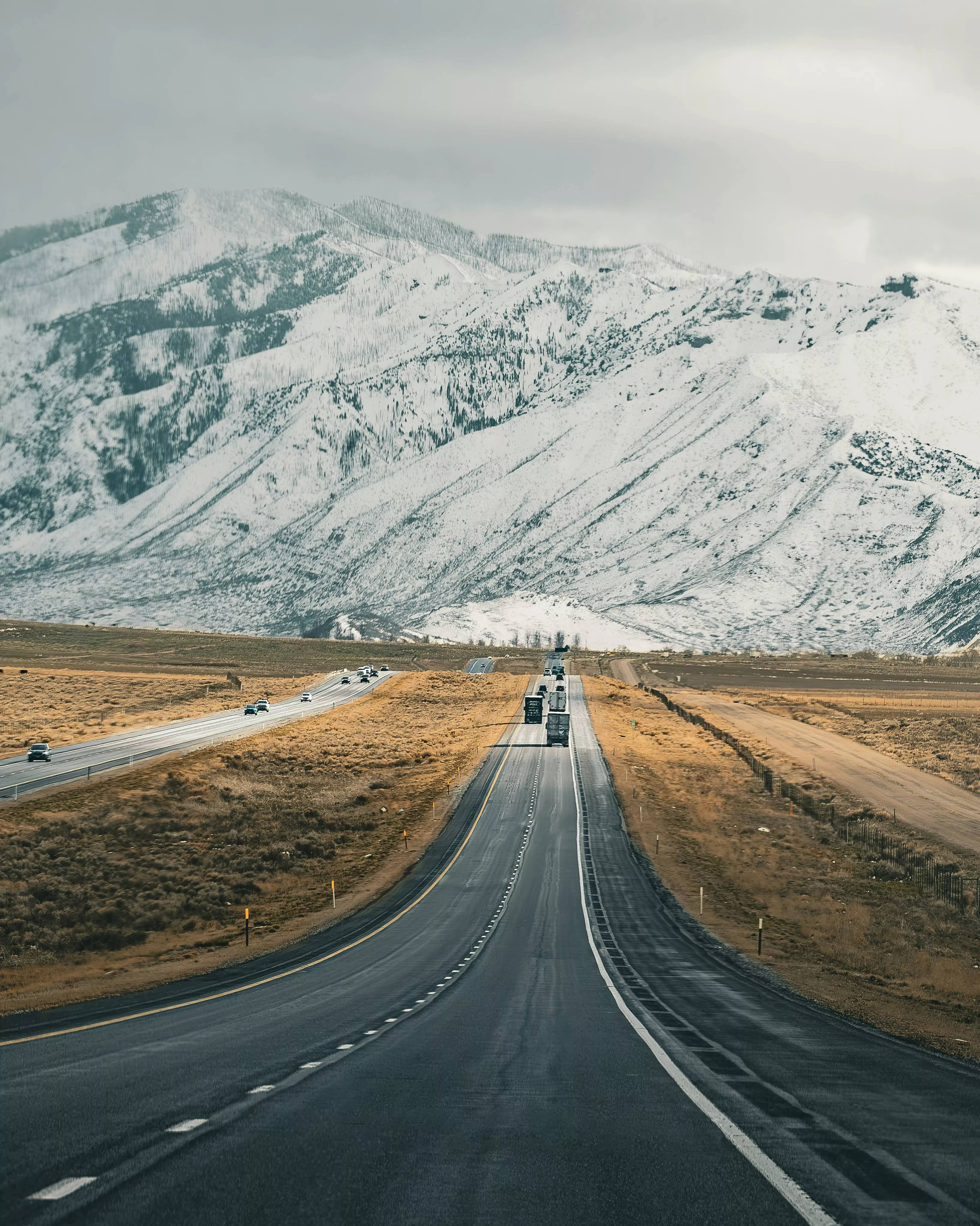Asphalt Road with Snowcapped Mountains