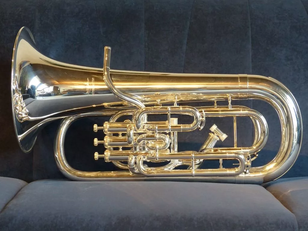A silver and gold trumpet sitting on a