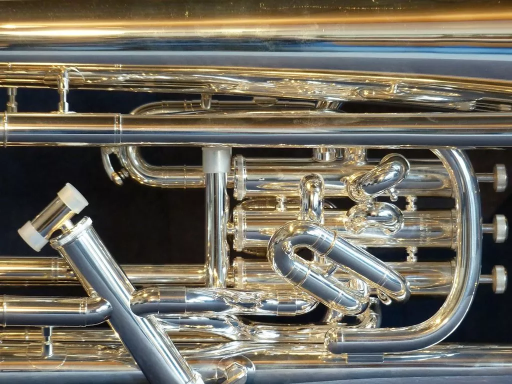 A close up of a silver and gold trumpet