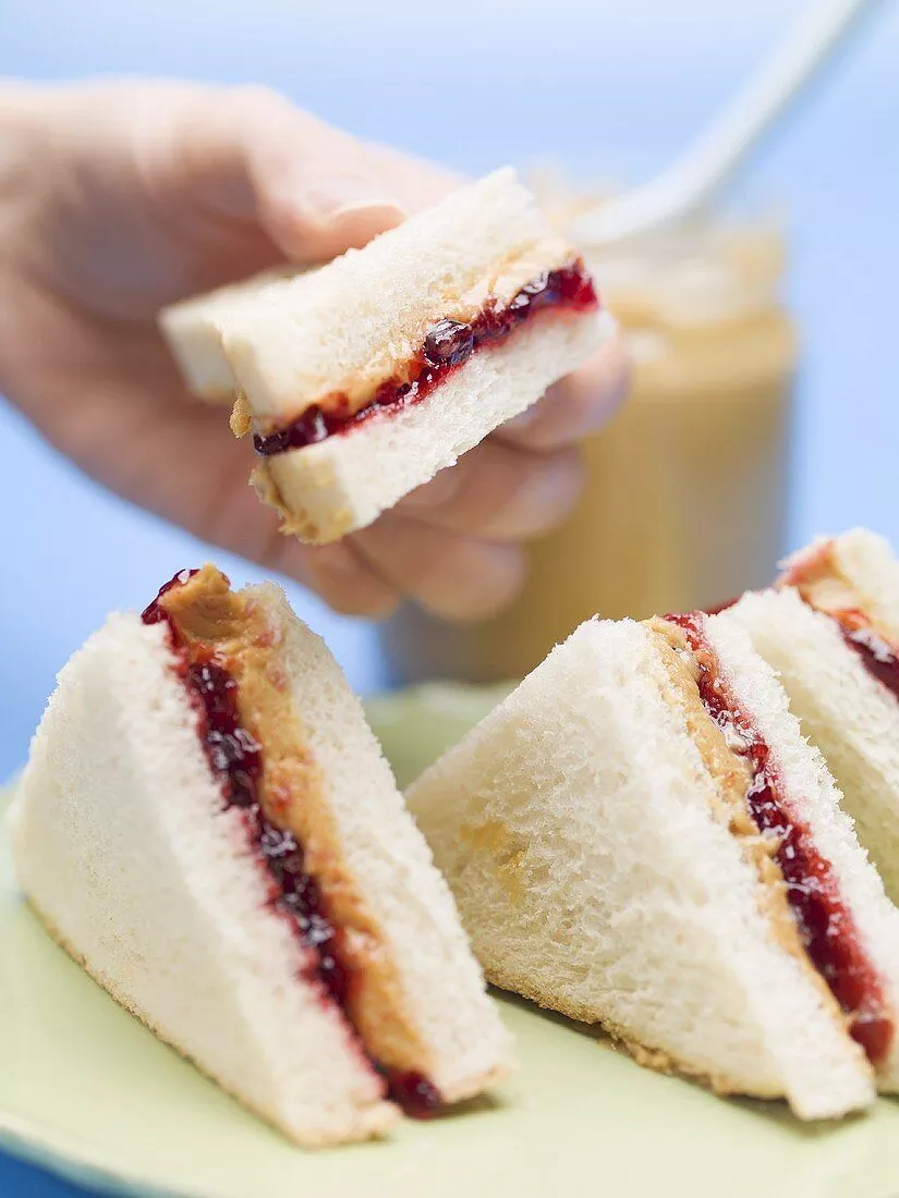 Hand holding peanut butter and jelly