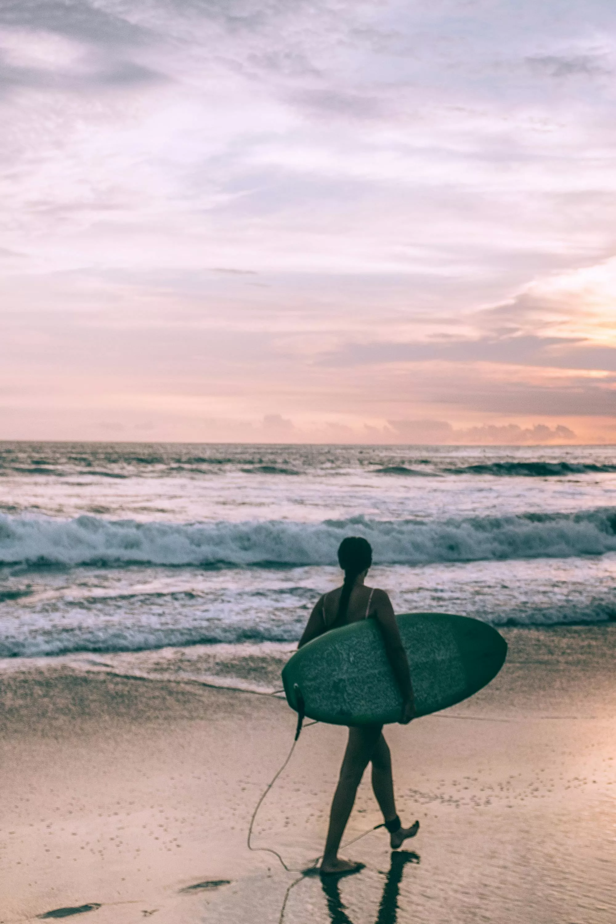 Female surfer with surfboard walking