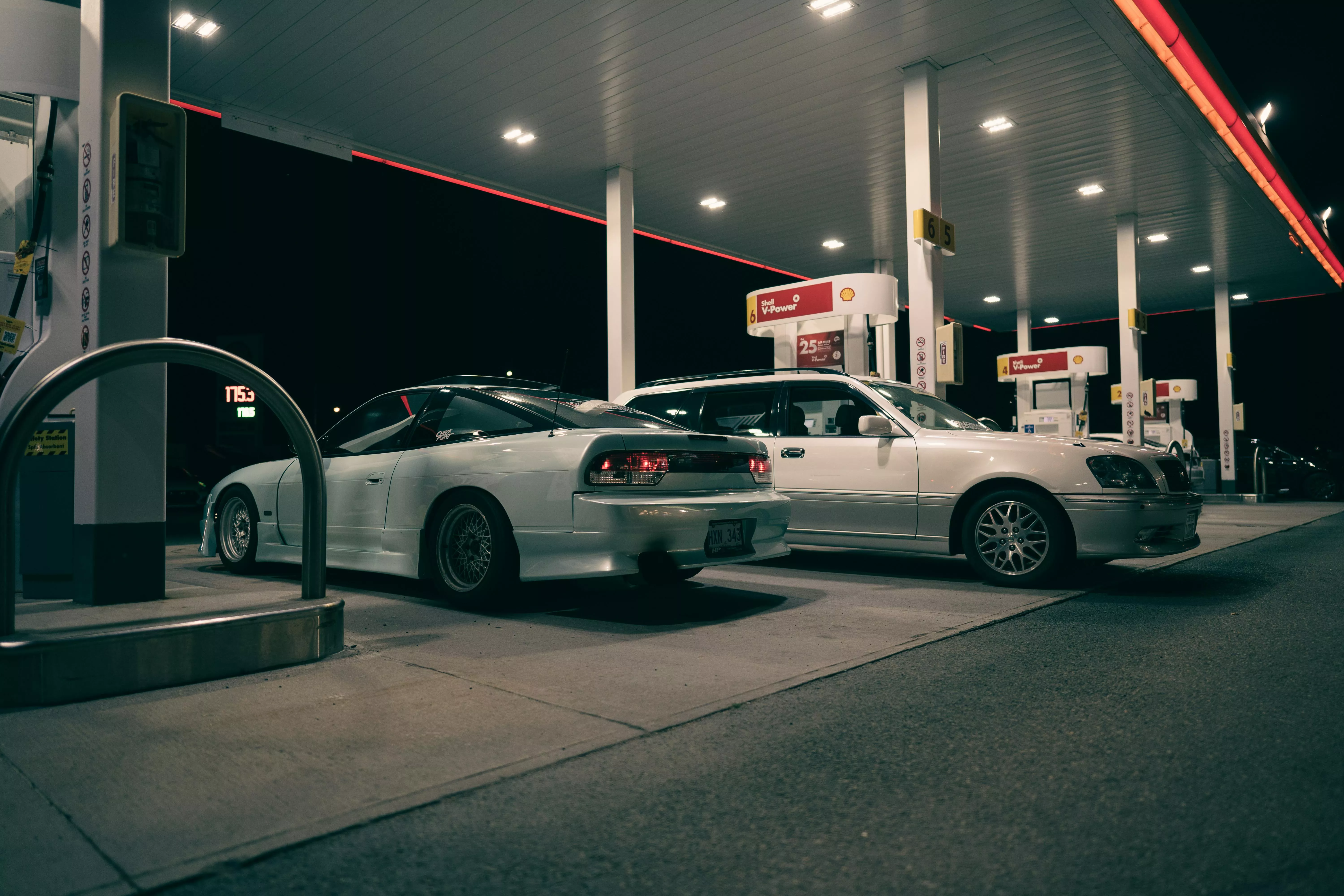 Two cars parked at a gas station at