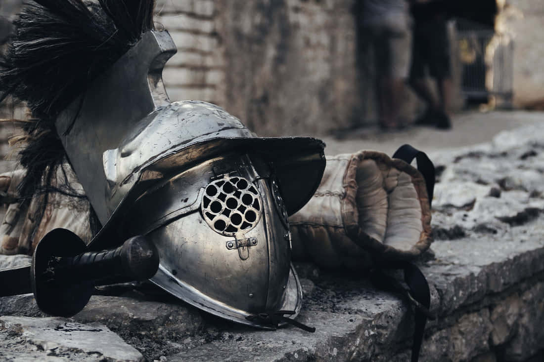 Helmet And A Sword On A Stone Wall