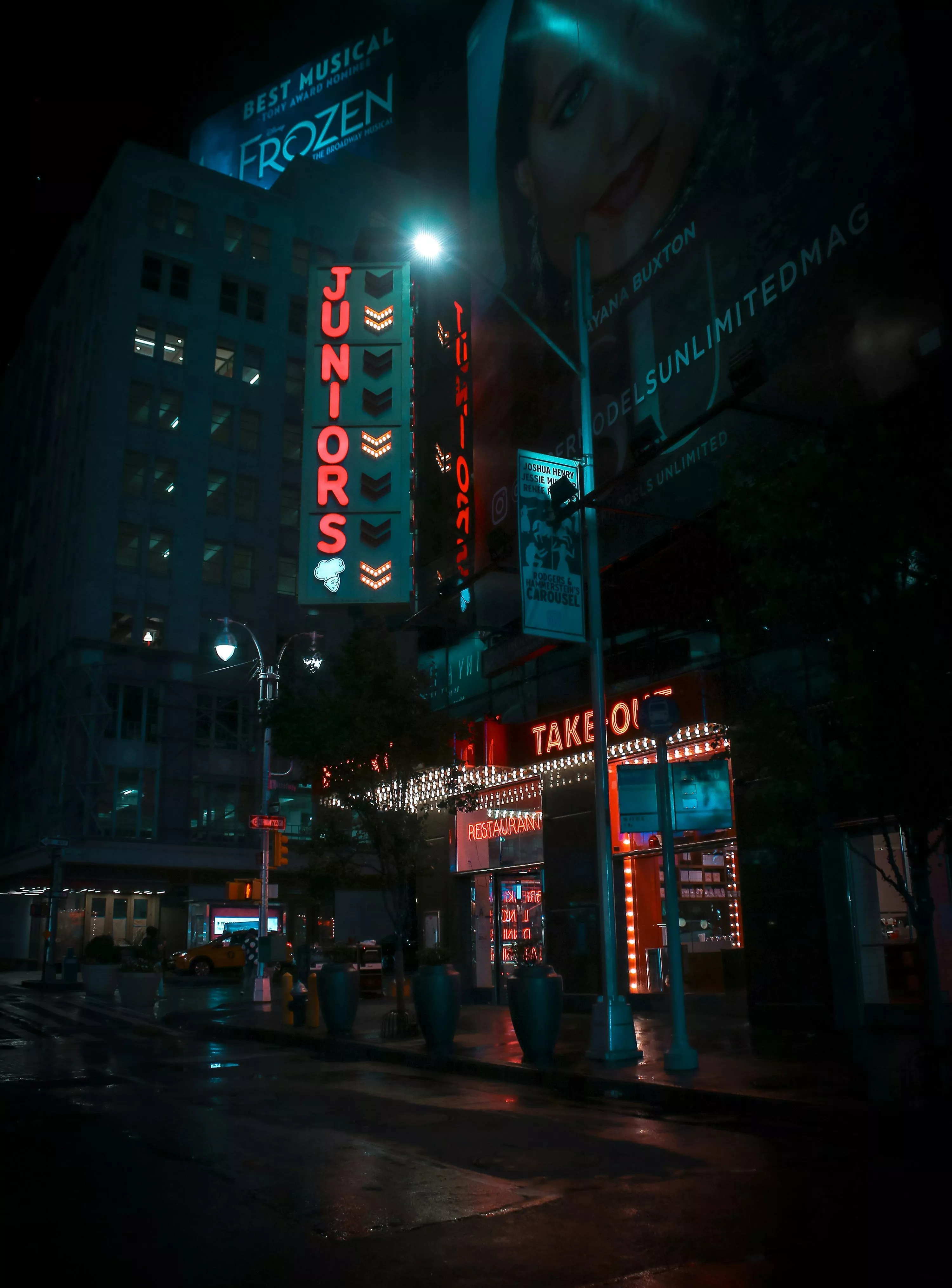 Empty road between buildings at night