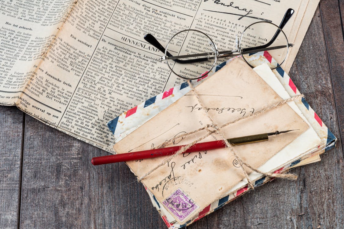 Eyeglasses on Newspaper Beside Mail