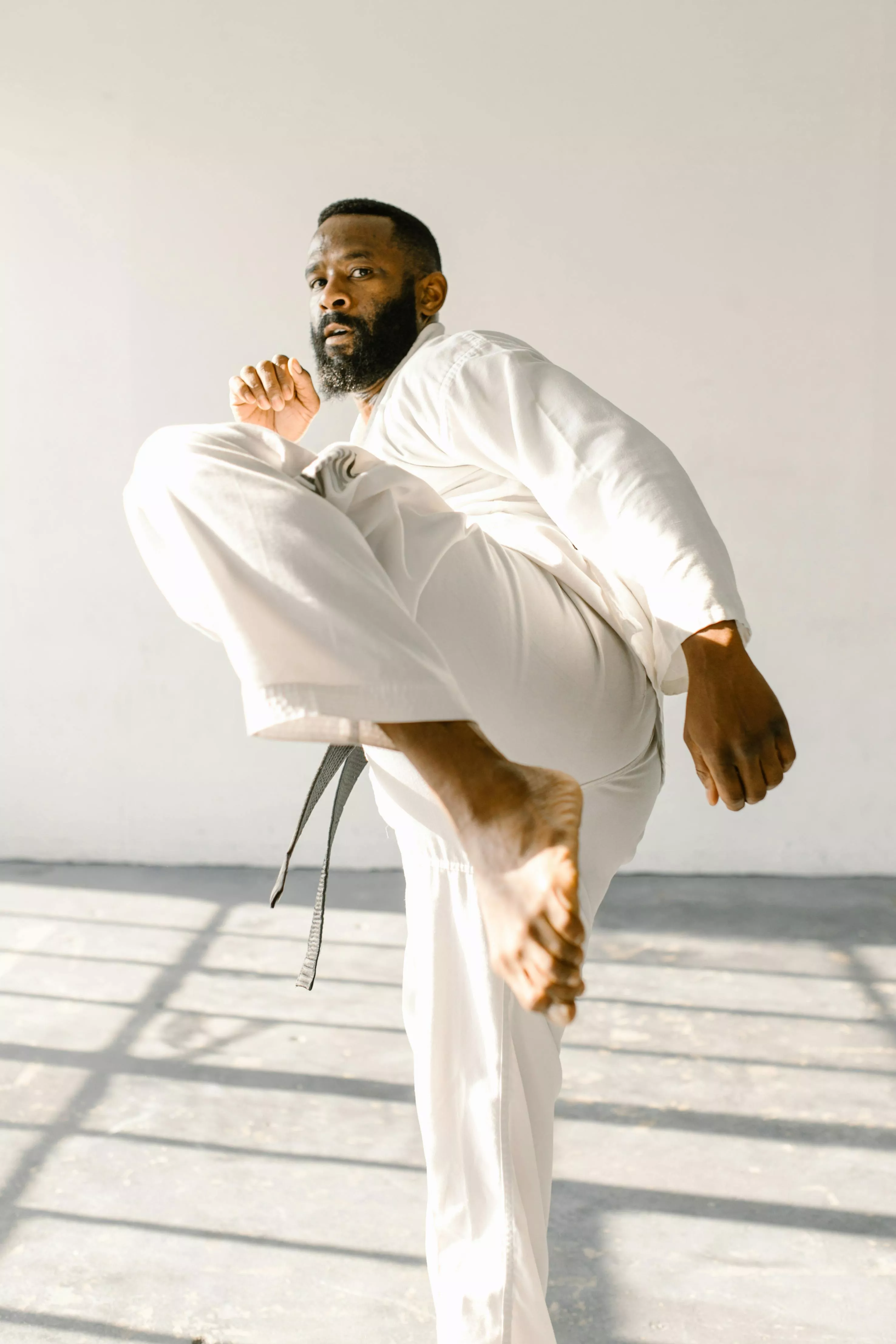 Man in White Judo Uniform in Kicking