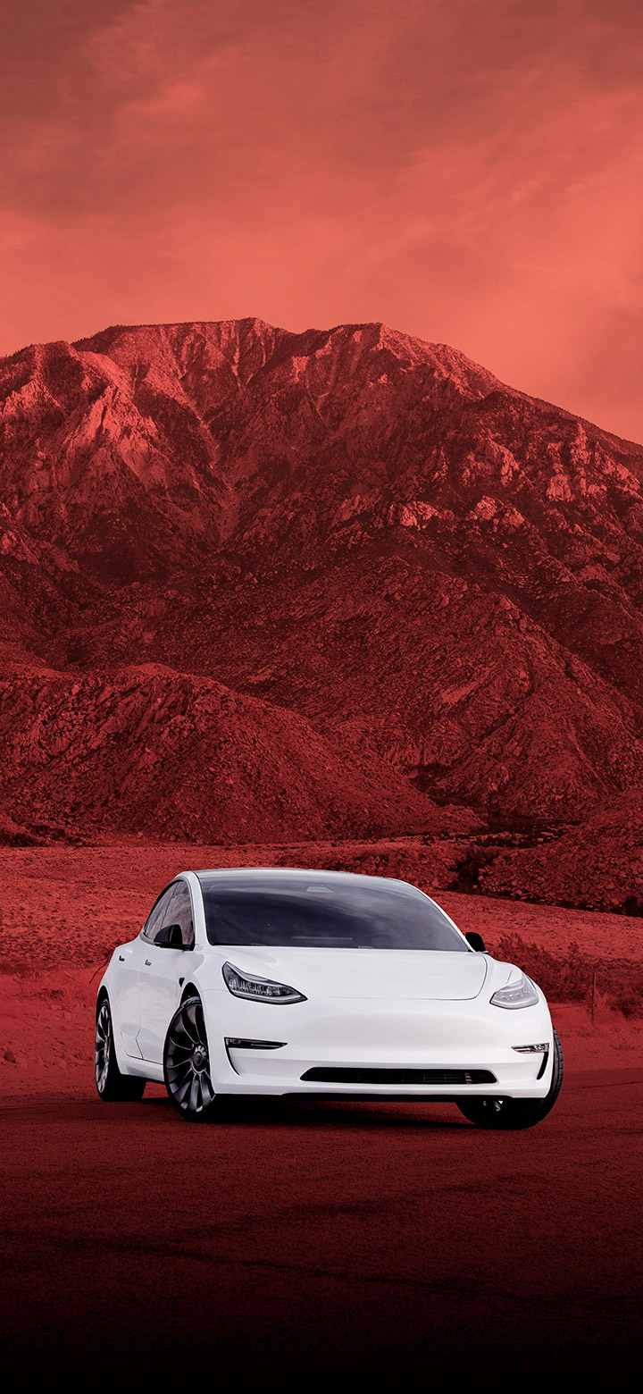 Tesla Parked In Front Of Red Mountain