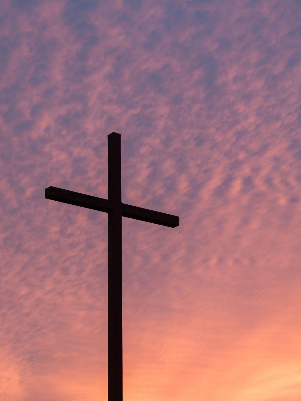 cross against a pink and purple sky