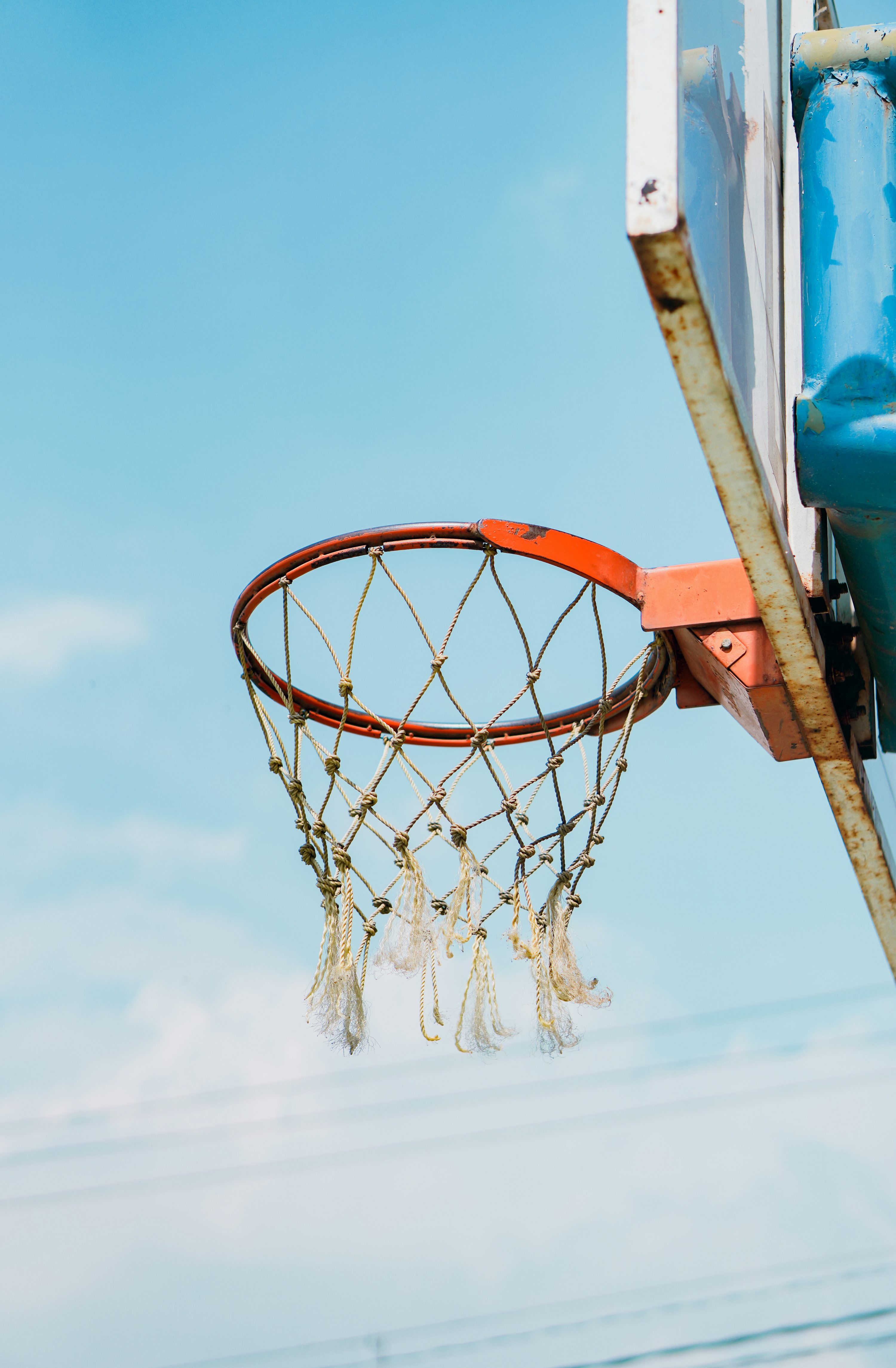 Orange basketball hoop under blue sky
