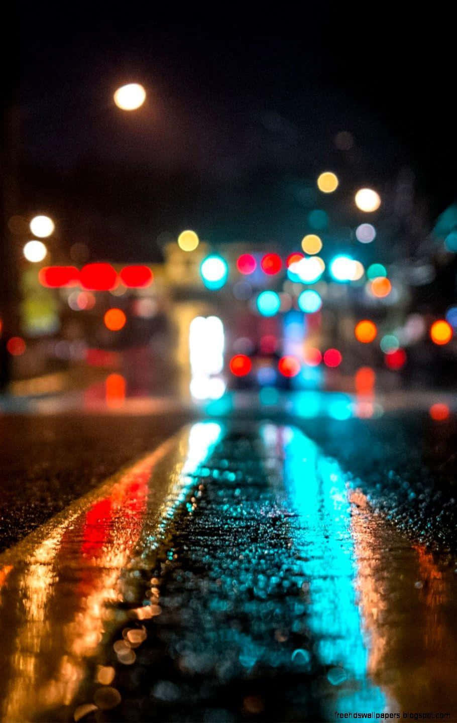 A Street With Lights And Rain On It