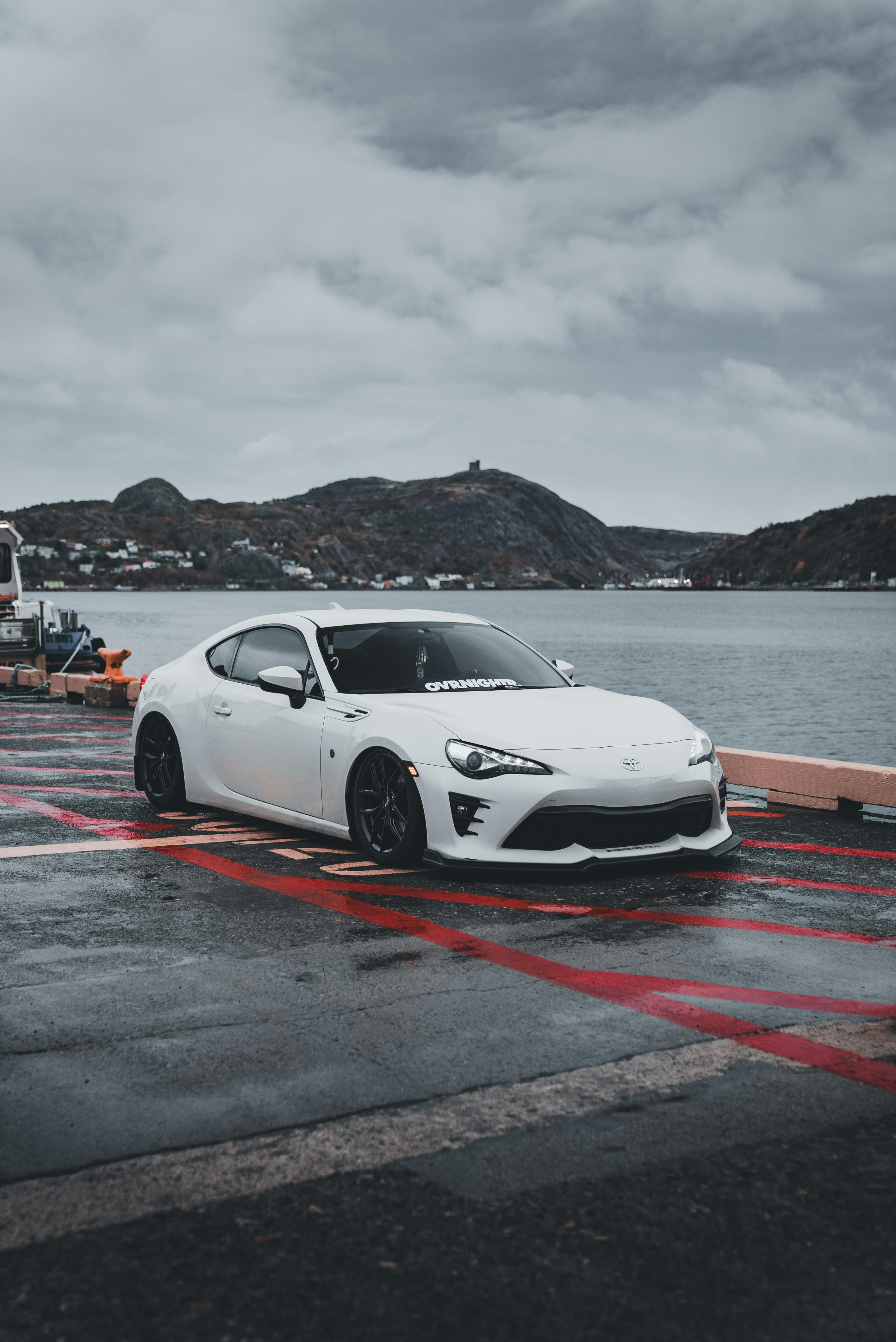 Sleek White Sports Car by Scenic Lakeside · Free