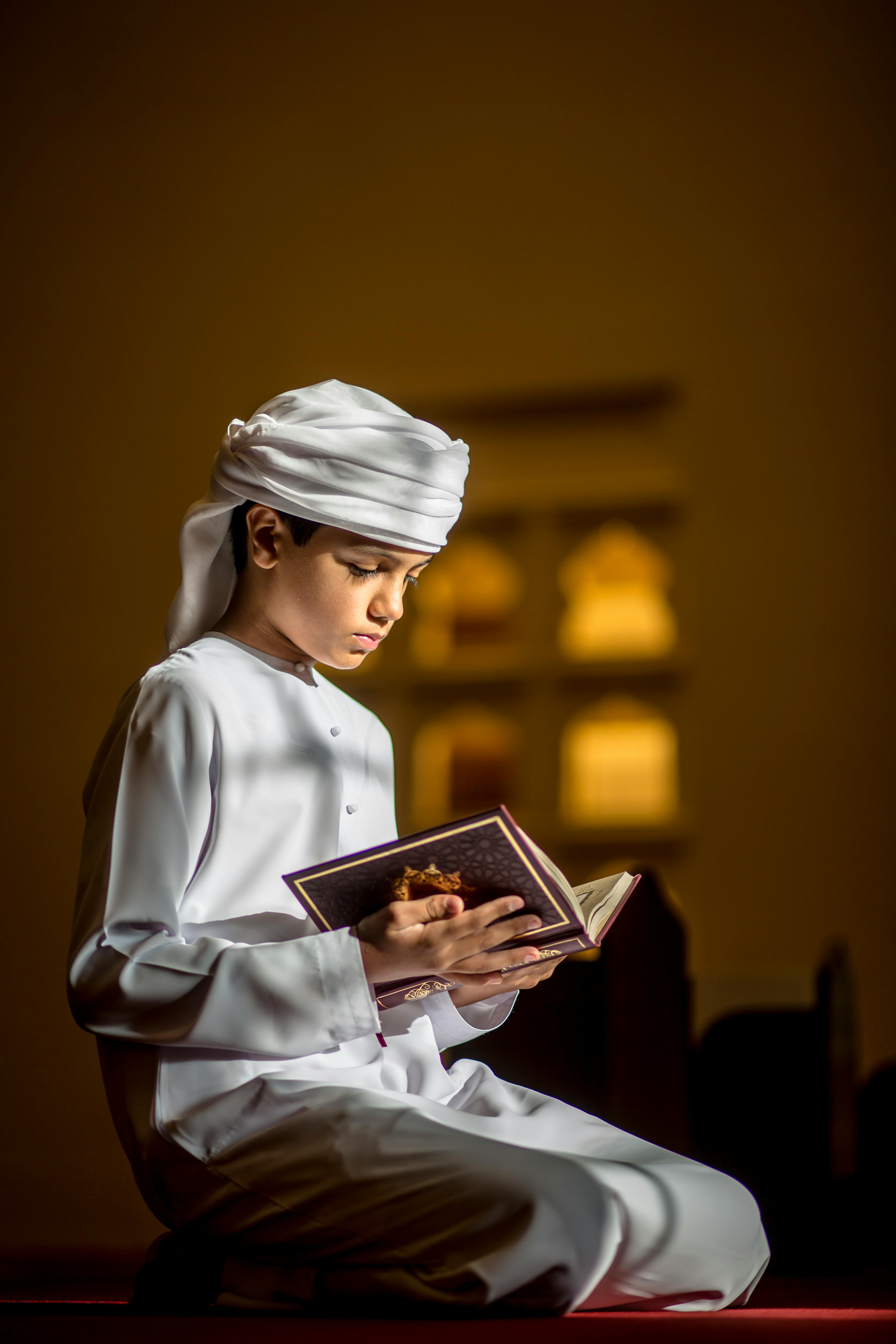 A Boy Sitting in a Mosque and Reading
