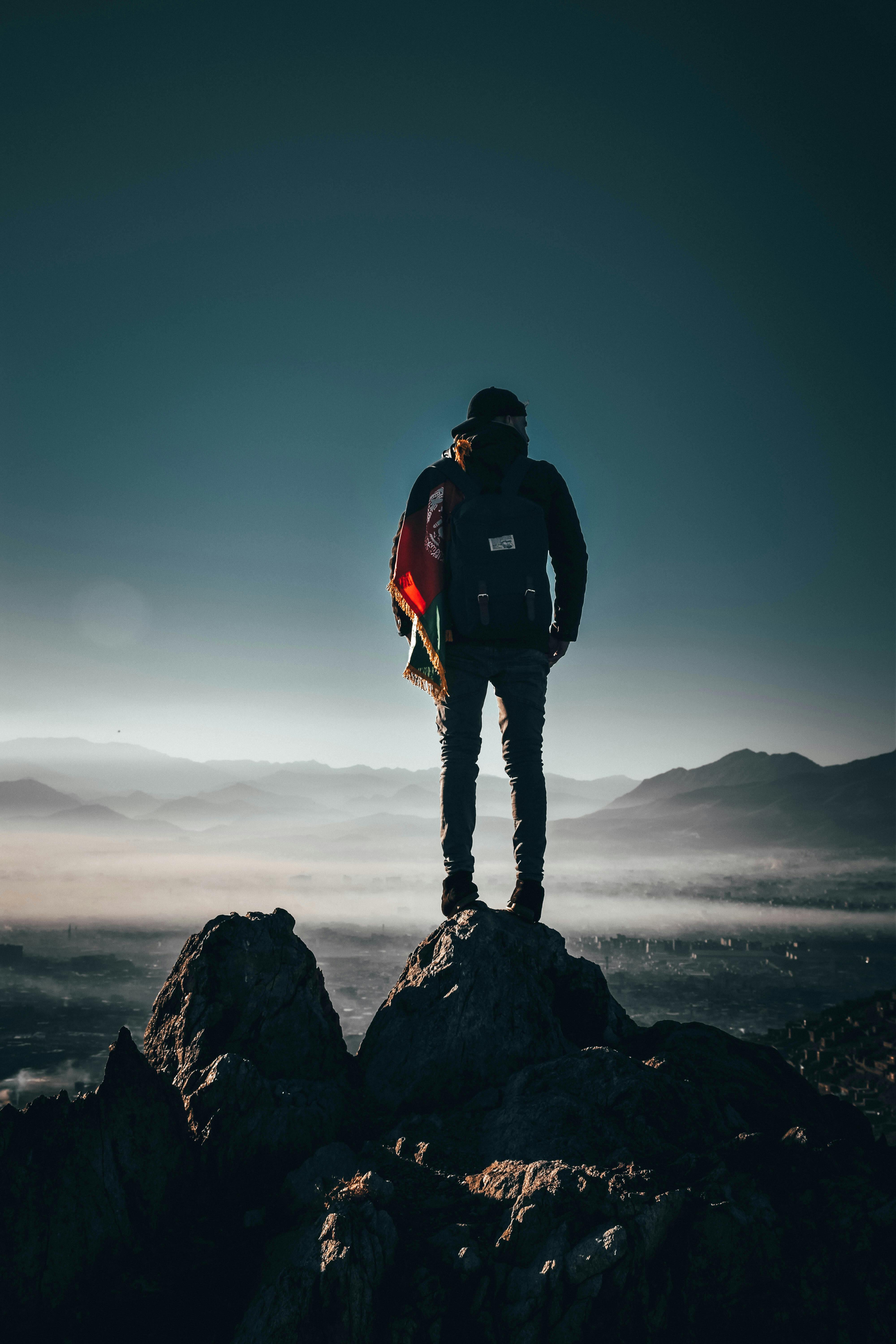 Man Carrying Backpack Standing on Rock