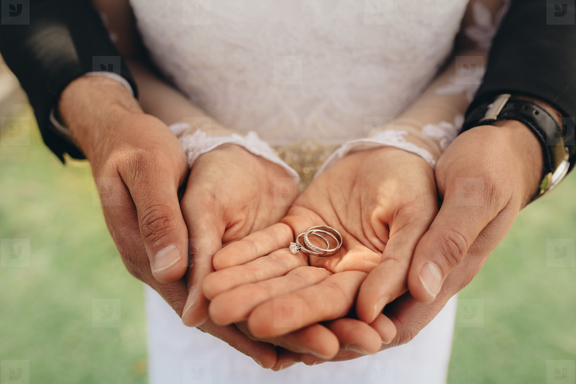 Bride And Groom Holding Wedding Rings