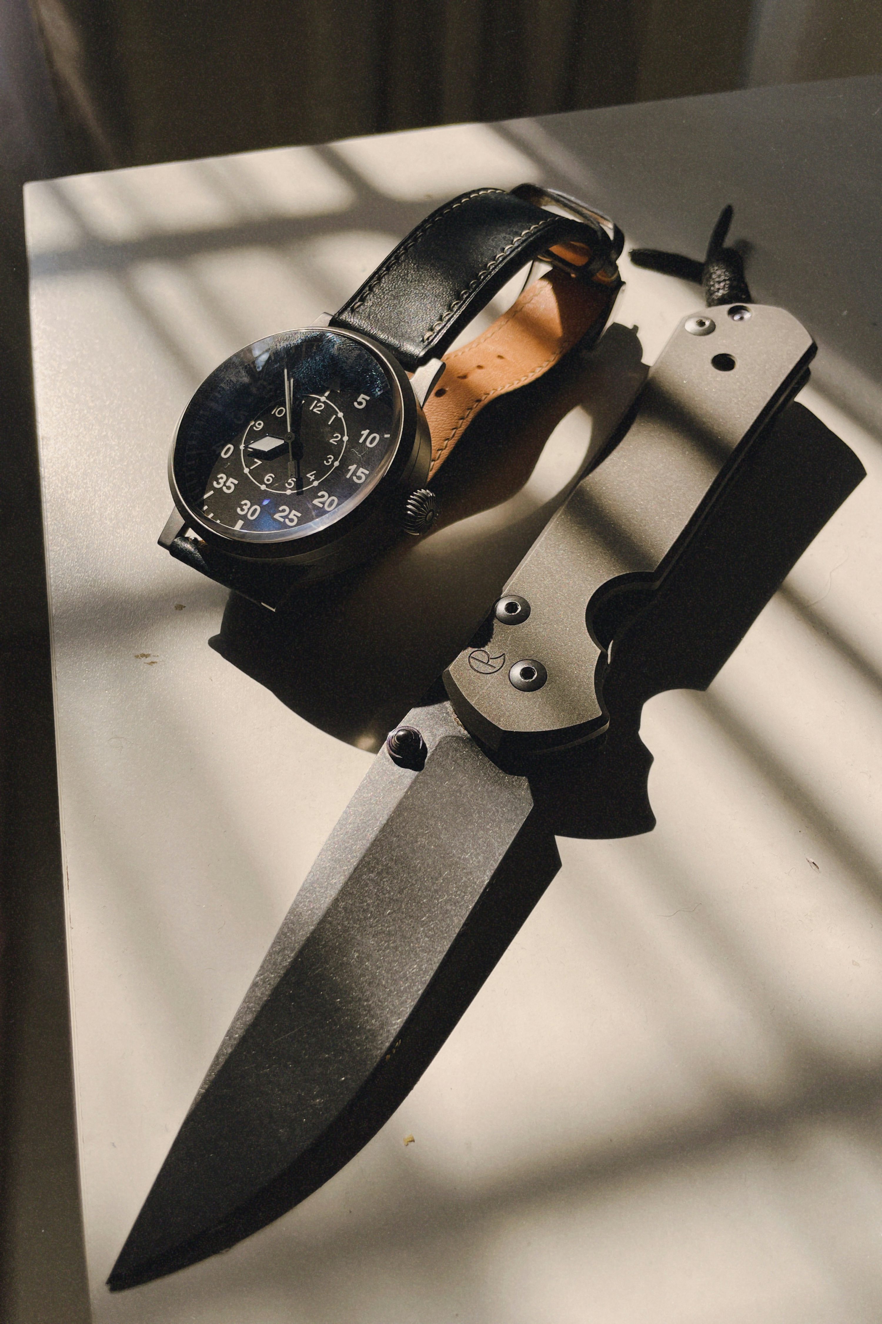 A knife and a watch on a table photo