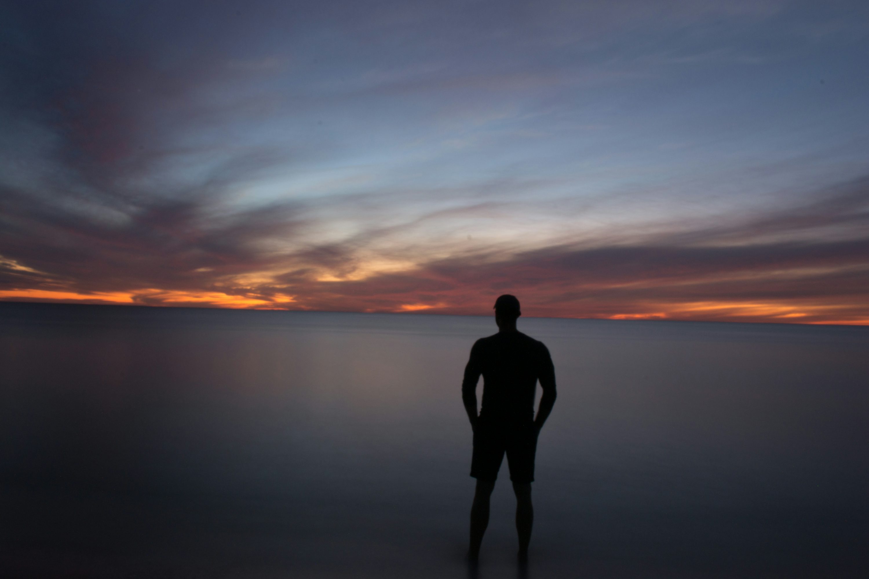 Silhouette of person standing near calm