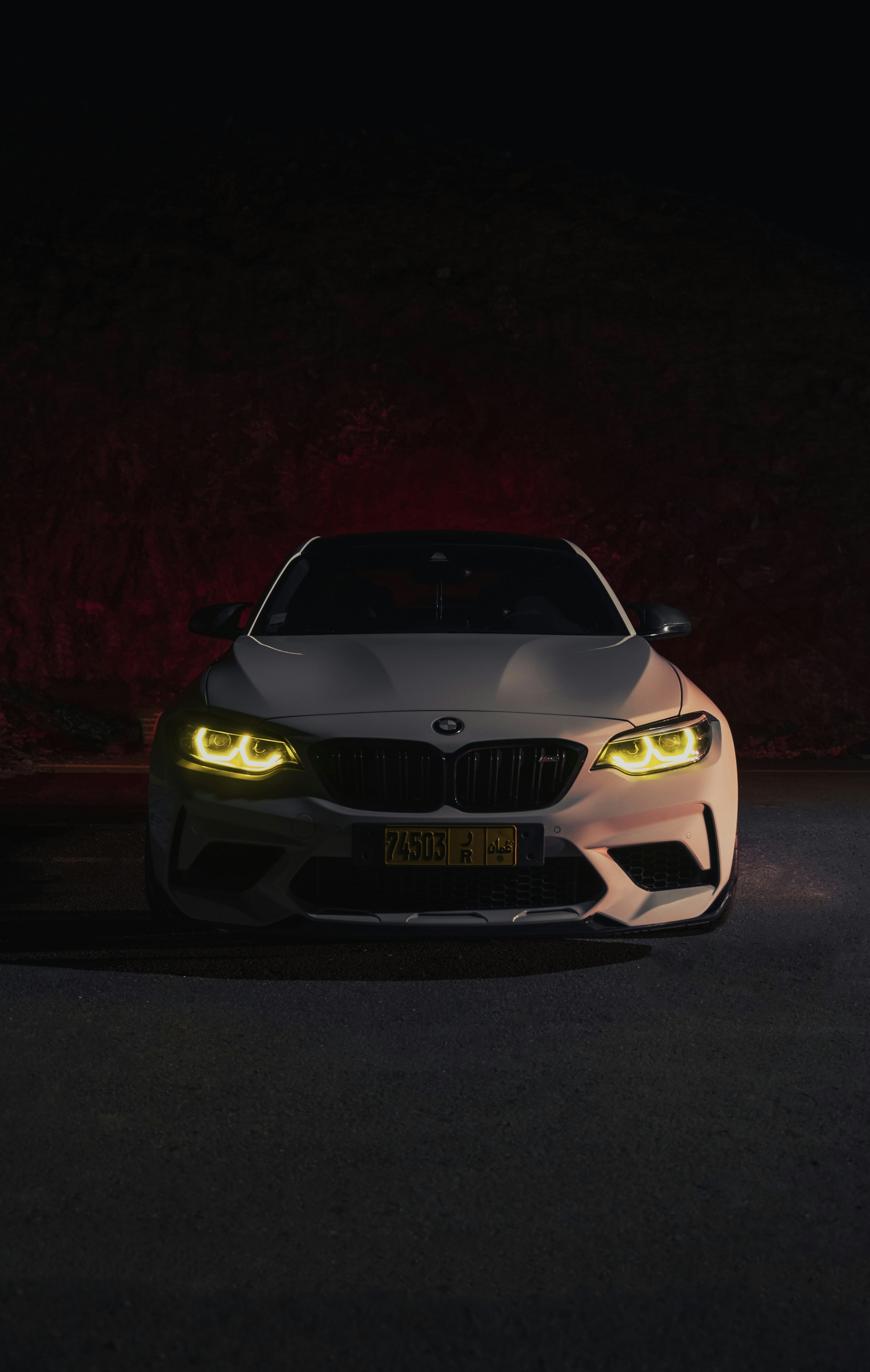 A white car with yellow eyes in the dark photo