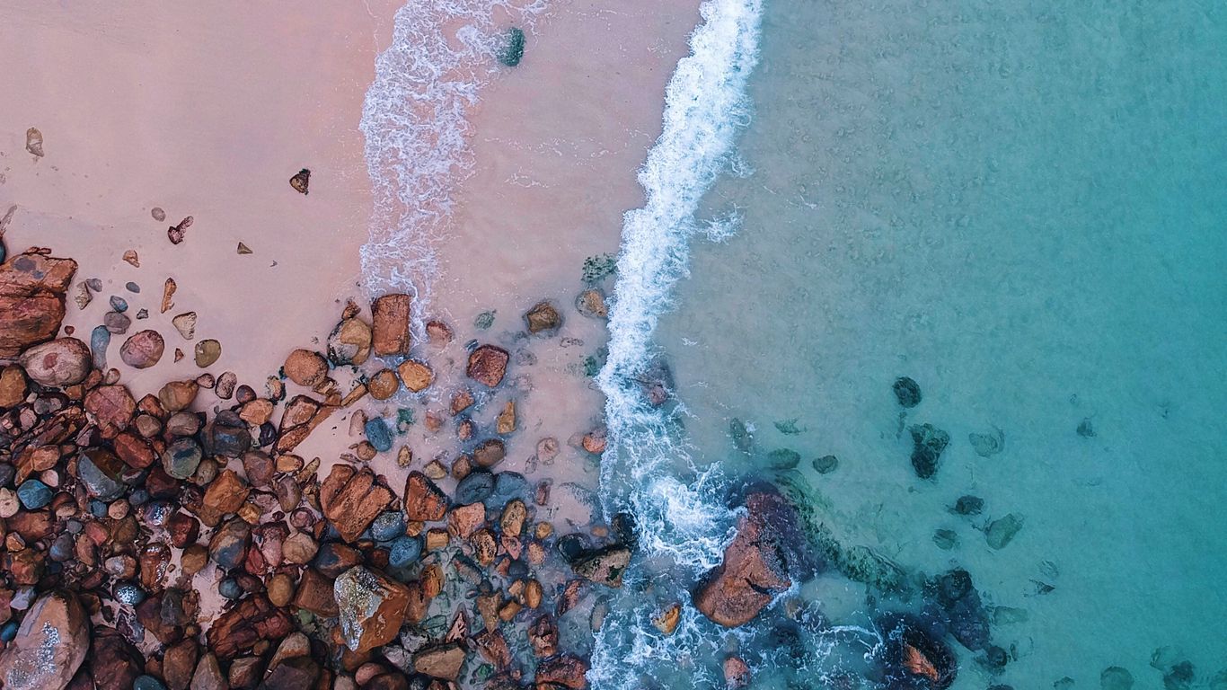 Download wallpaper 1366x768 ocean, beach, aerial view, sand, stones, surf, foam tablet, laptop HD background