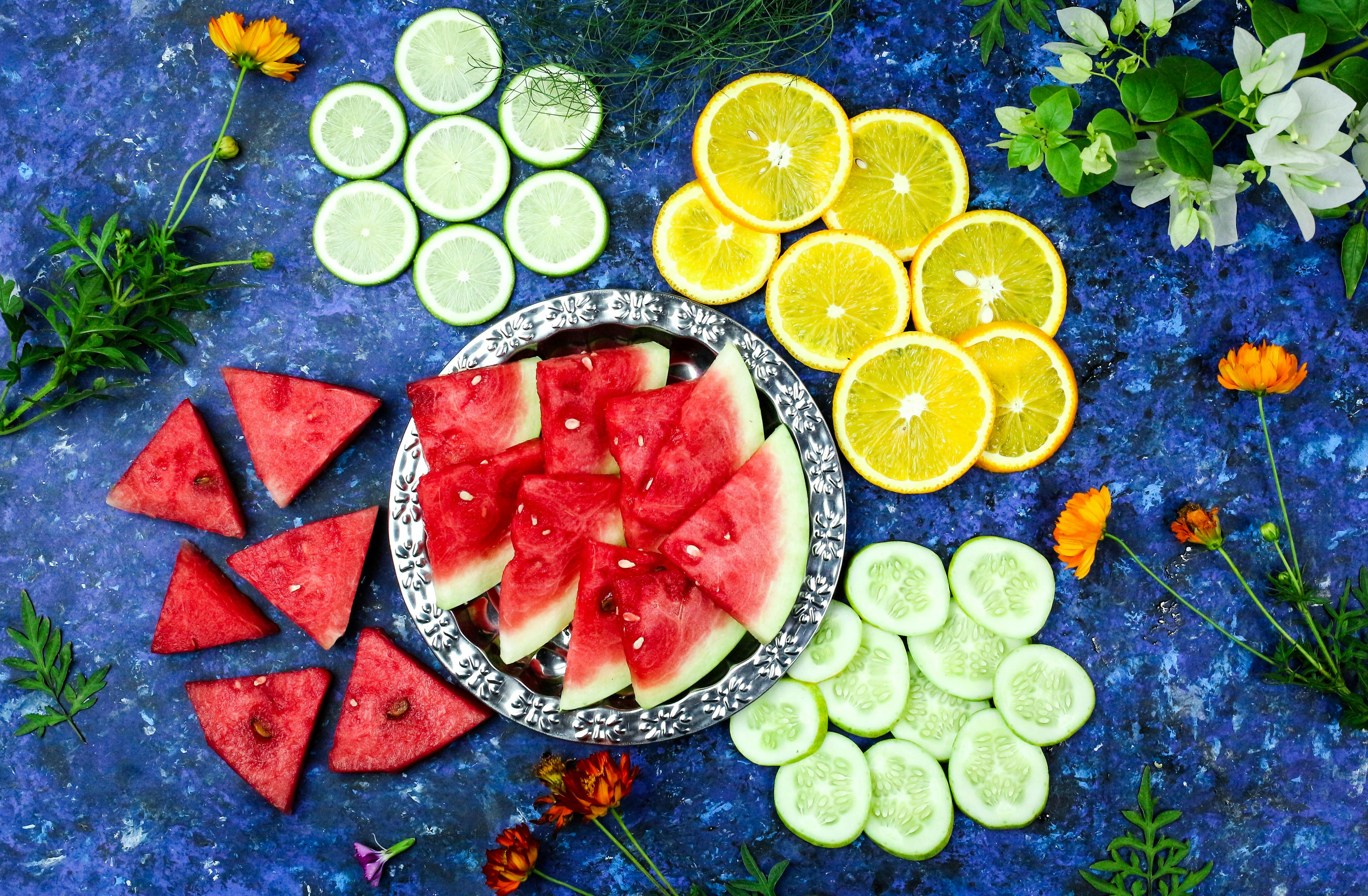 Slices of Tropical and Citrus Fruits on Blue Surface · Free