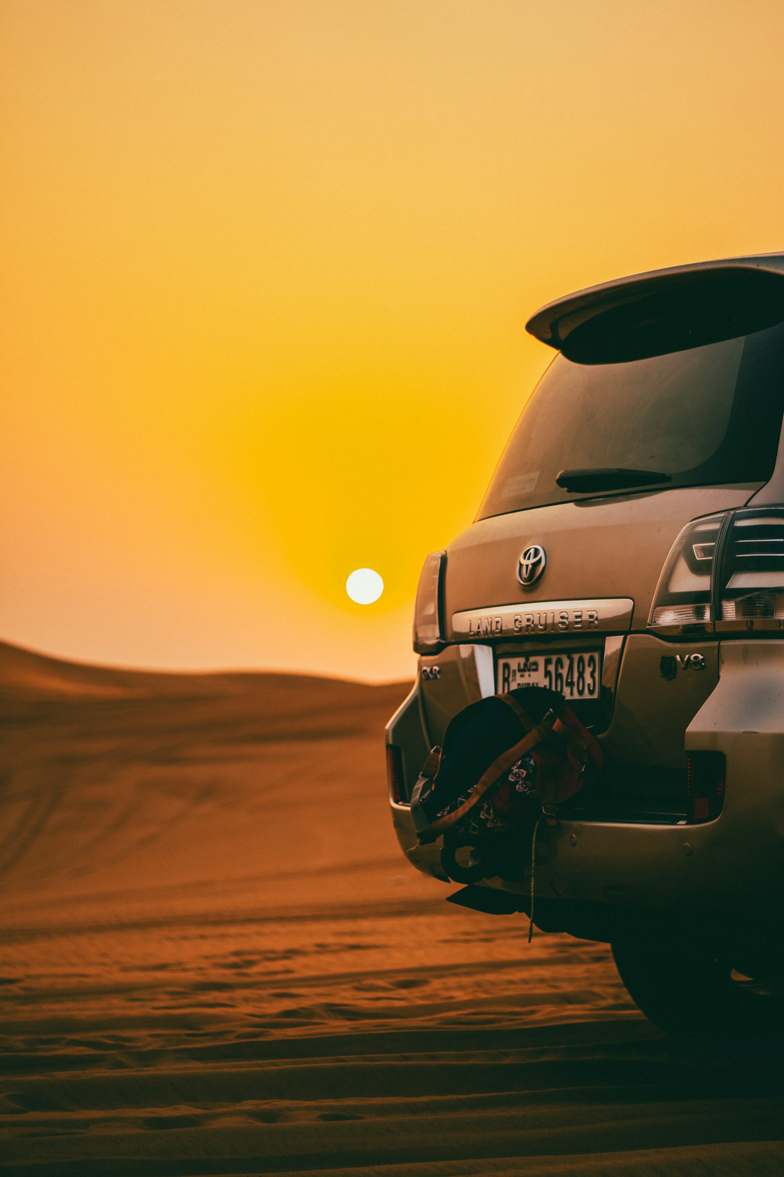 Black Toyota Land Cruiser SUV on desert during golden hour photo