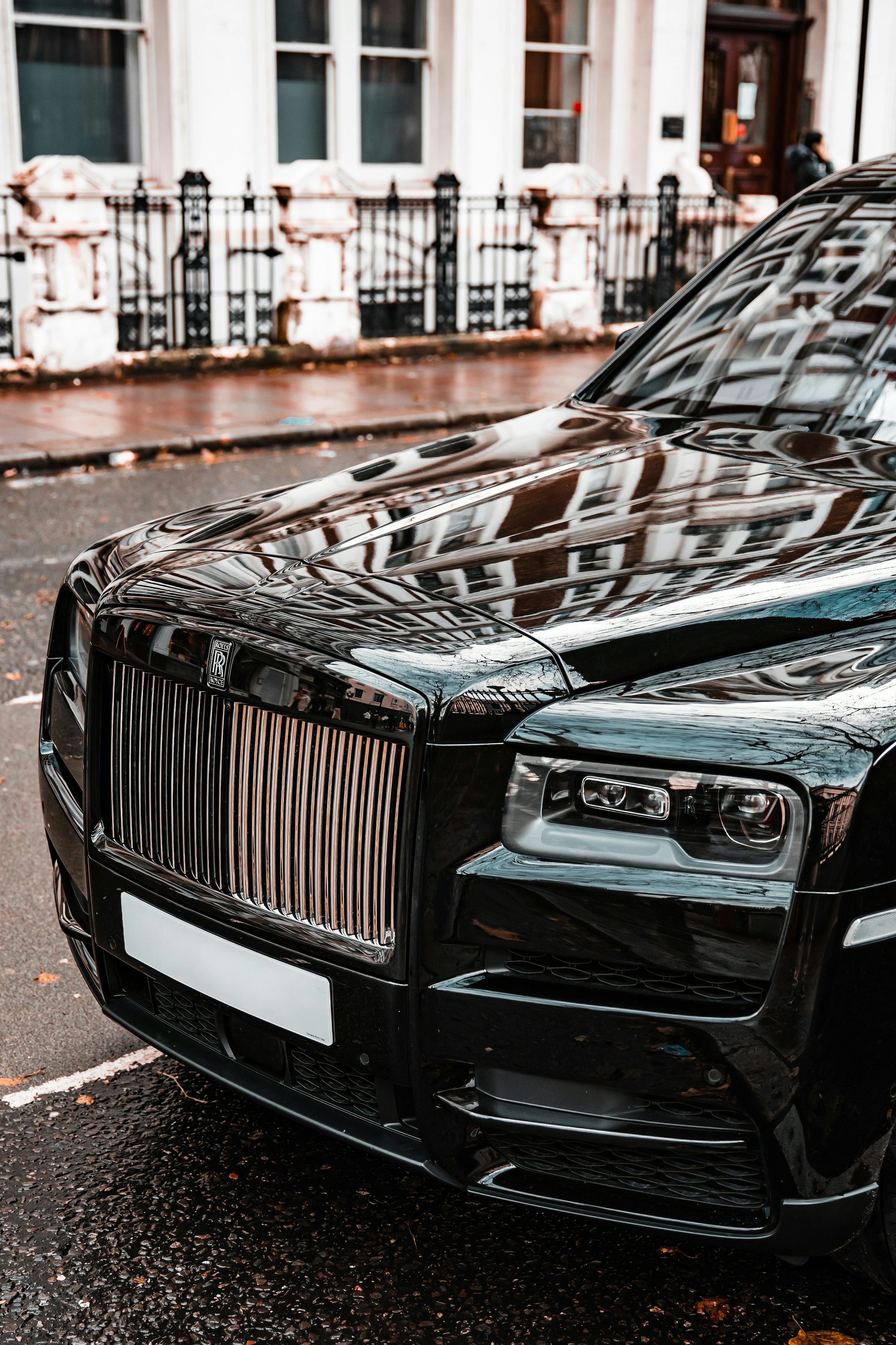 A yellow rolls royce parked on the side of the road photo