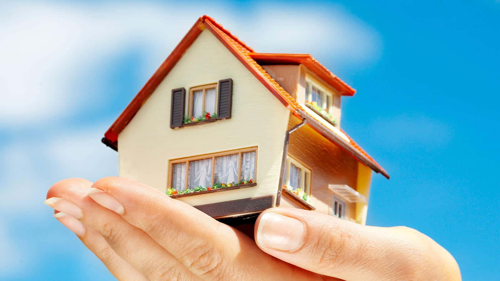 Download A Person Holding A Model House In Their Hand