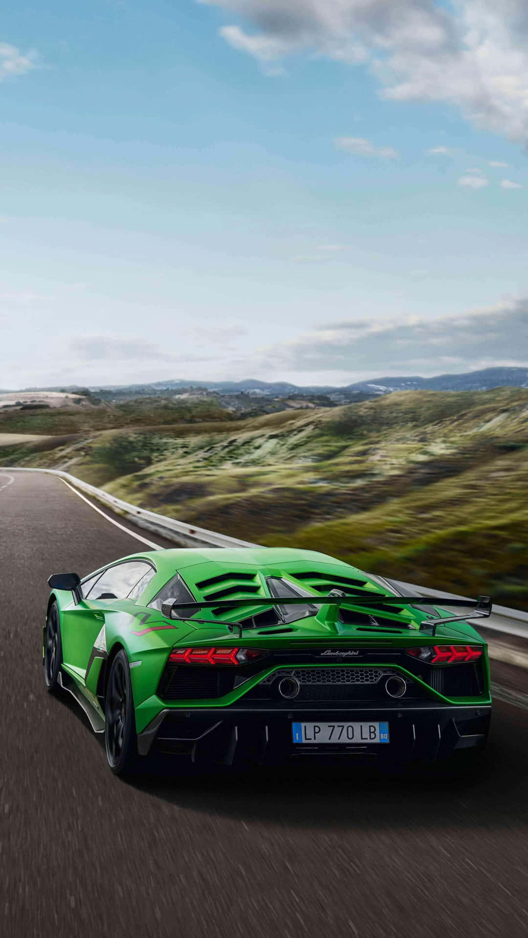 Download The Green Lamborghini Huracan Is Driving Down A Road Wallpaper