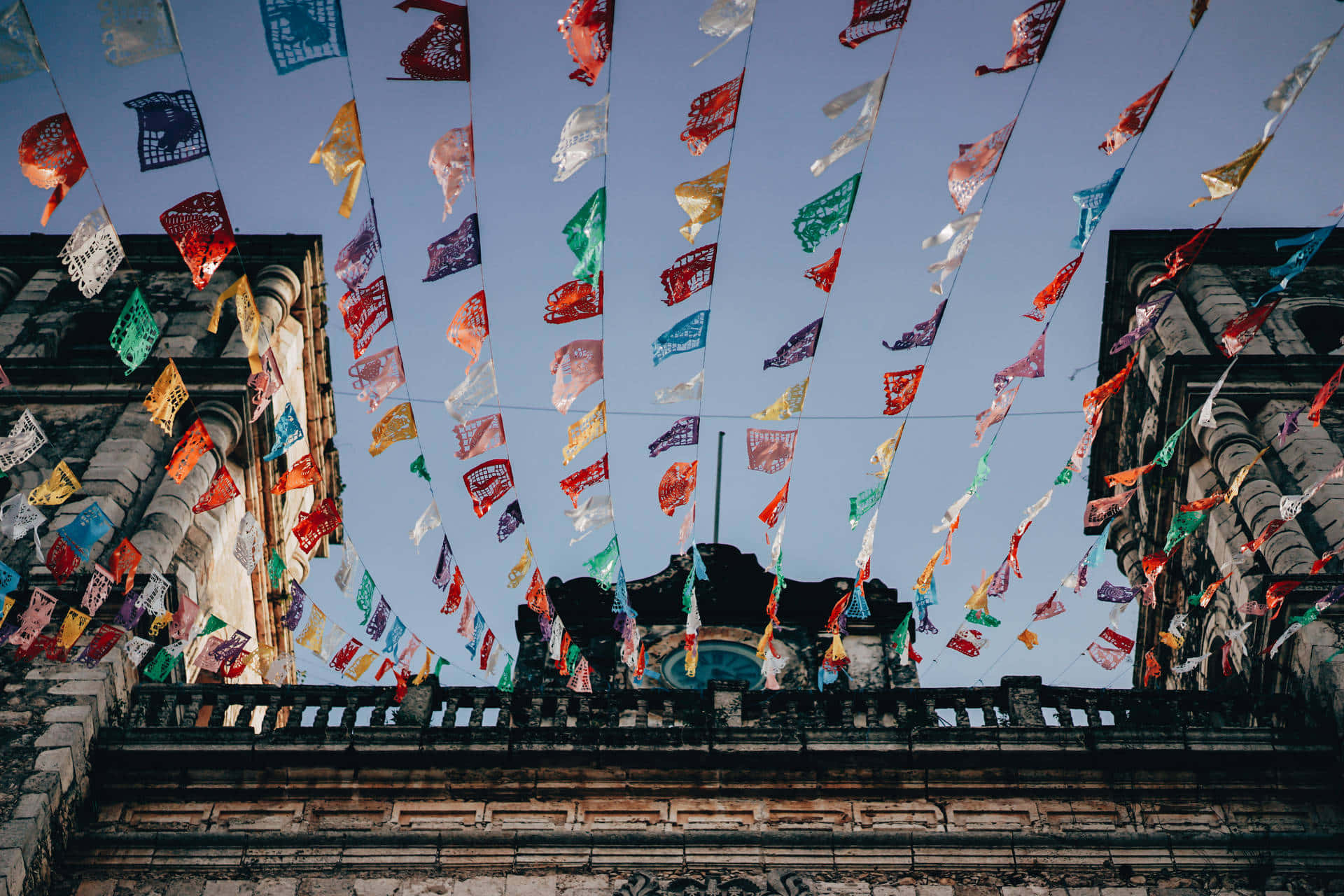 Download Mexican Fiesta Flags Over Colonial Architecture Wallpaper