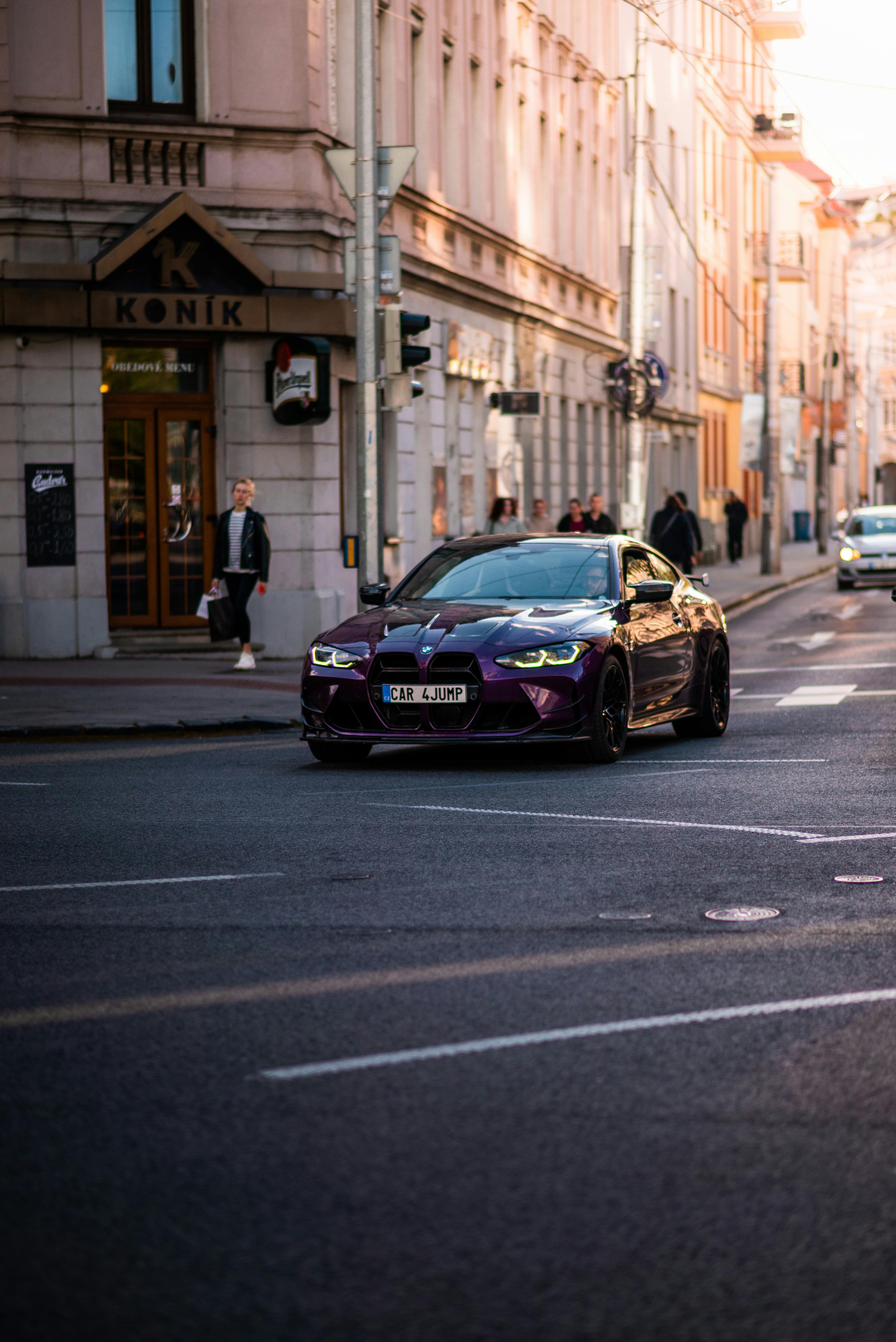 Purple BMW M4 G82 Driving Down the Street · Free