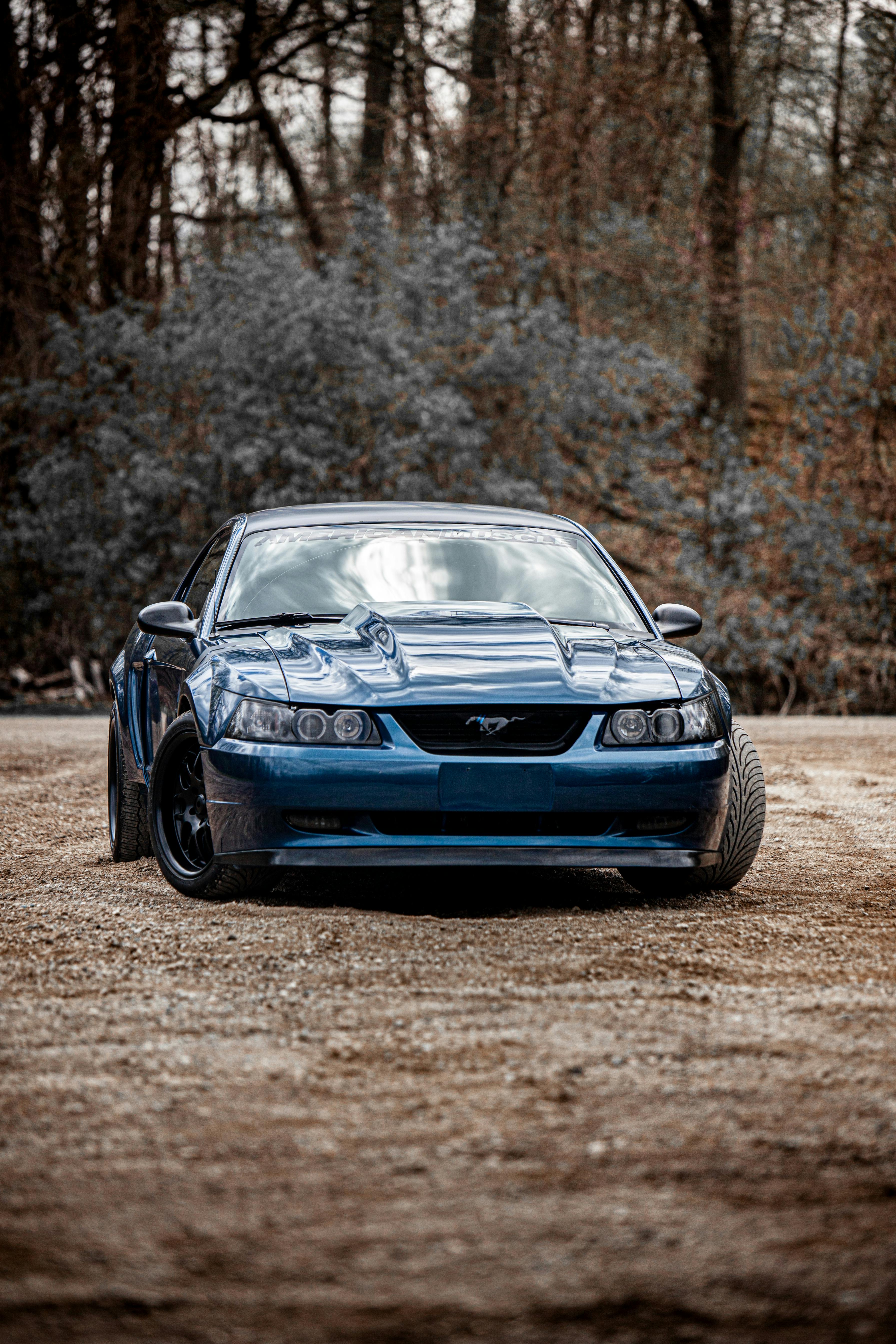 A Blue Ford Mustang Parked Near Trees · Free