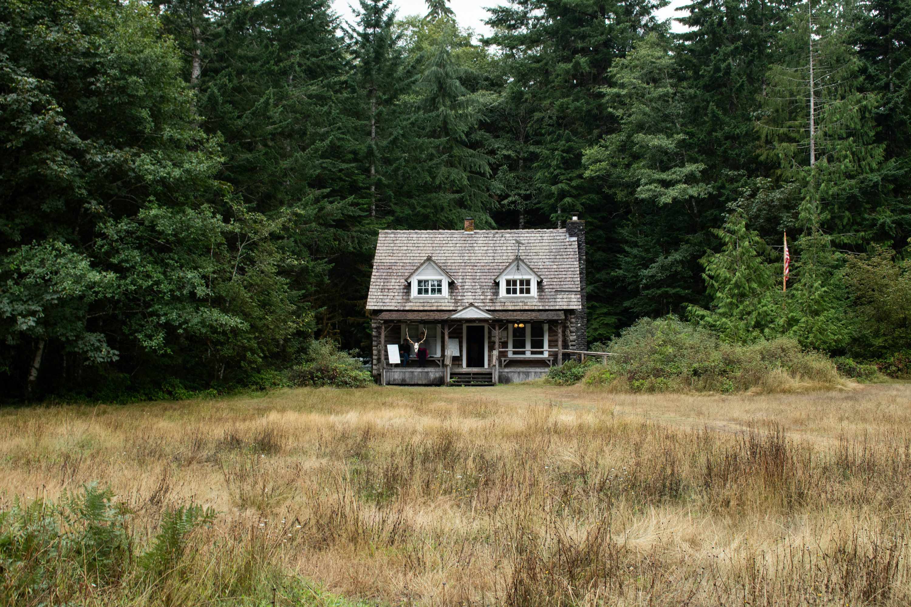 A house in the middle of a field with trees in the background photo